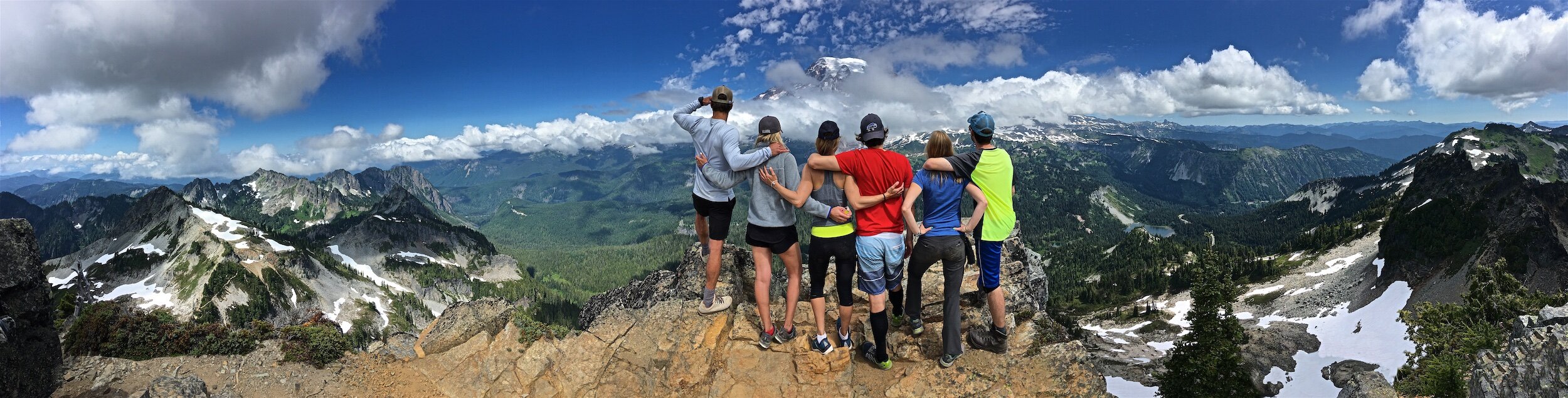 A group of hiking friends enjoy the view of Mount Hood together from the top of the rocky cliffs in Mount Hood national forest Oregon.jpeg