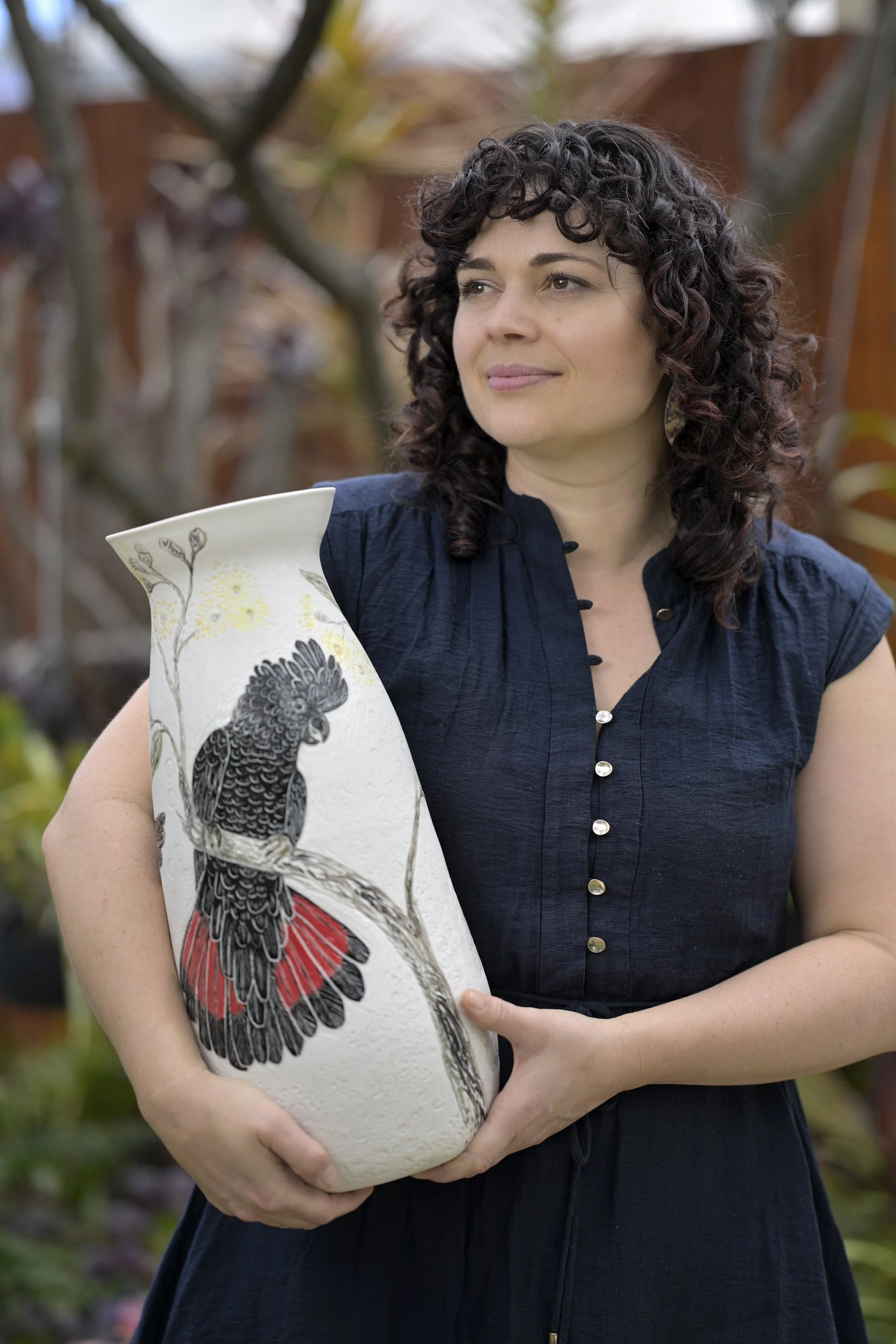Danica Wichtermann from Rediscover Ceramics, holding large porcelain vase featuring black cockatoos