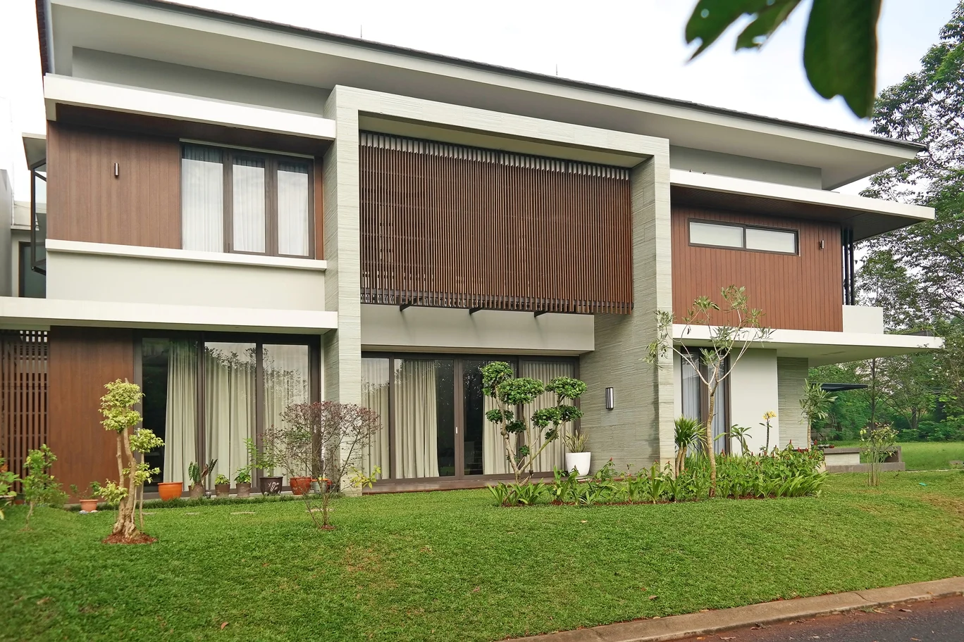 Narada IV commenced its construction in early 2015 and was completed in mid 2016. The house incorporates combined use of synthetic wood and xiolit andesite. The long stretch of side elevation is softened with the vertical orders of sythetic wood cladding and screen, while the focal middle porch is highlighted and framed with xiolit andesite stone. 