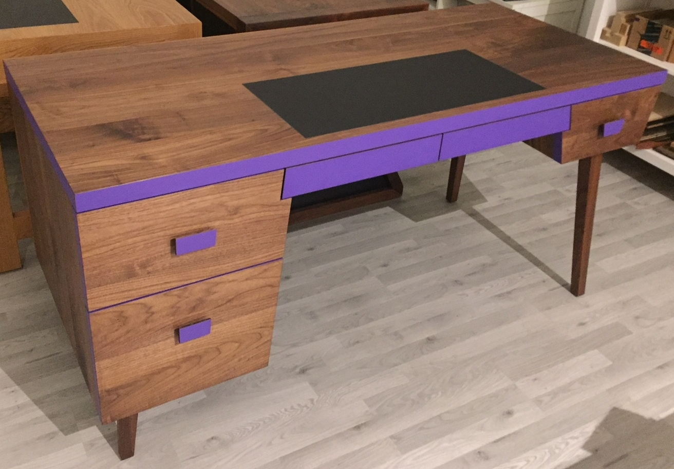 A young adult's study desk built in solid Walnut paired with trendy royal purple laminate and black leather insert for writing. Adding on a bit of tradition to this chic piece.