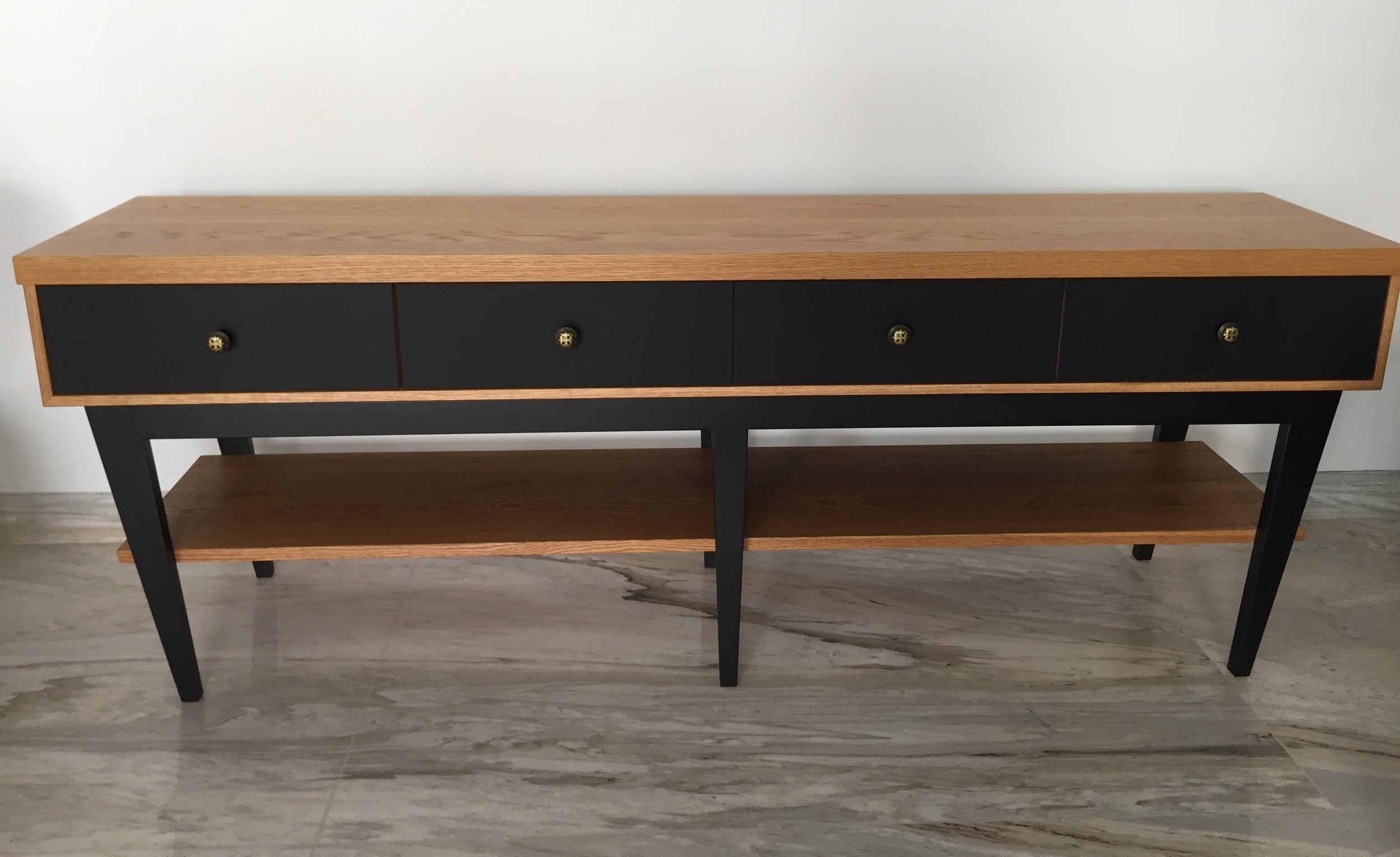 A sideboard for the living room using EDL's Fenix Black laminate and solid Oak wood. We designed 4 drawers on slant legs to give this classic piece an edge.