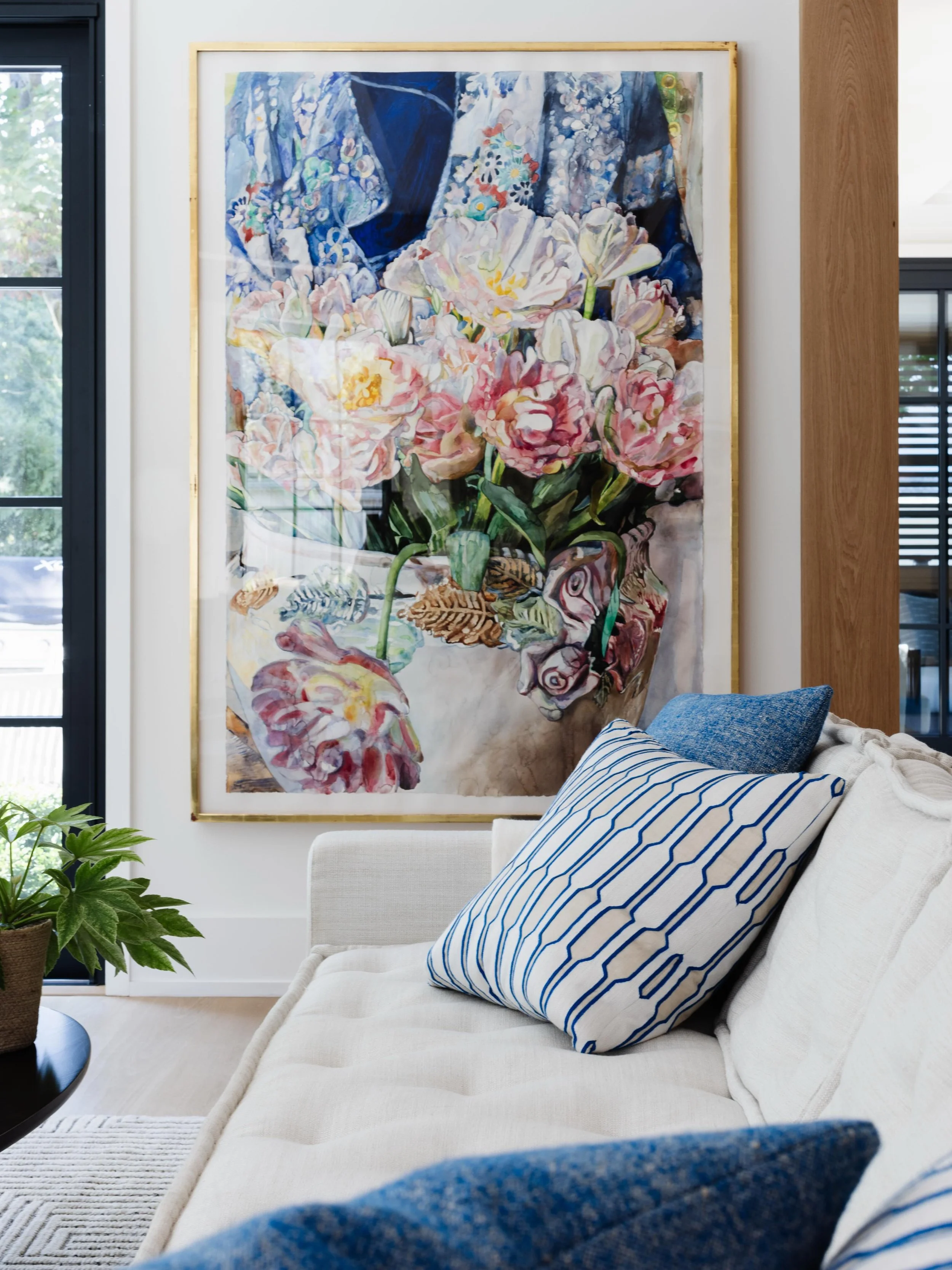 Choosing oversized artwork is one of the best ways to ground a living room, giving the eye a beautiful place to land while setting the tone for the entire design. A crisp, neutral cream sofa provides a quiet foundation while the geometric and texture