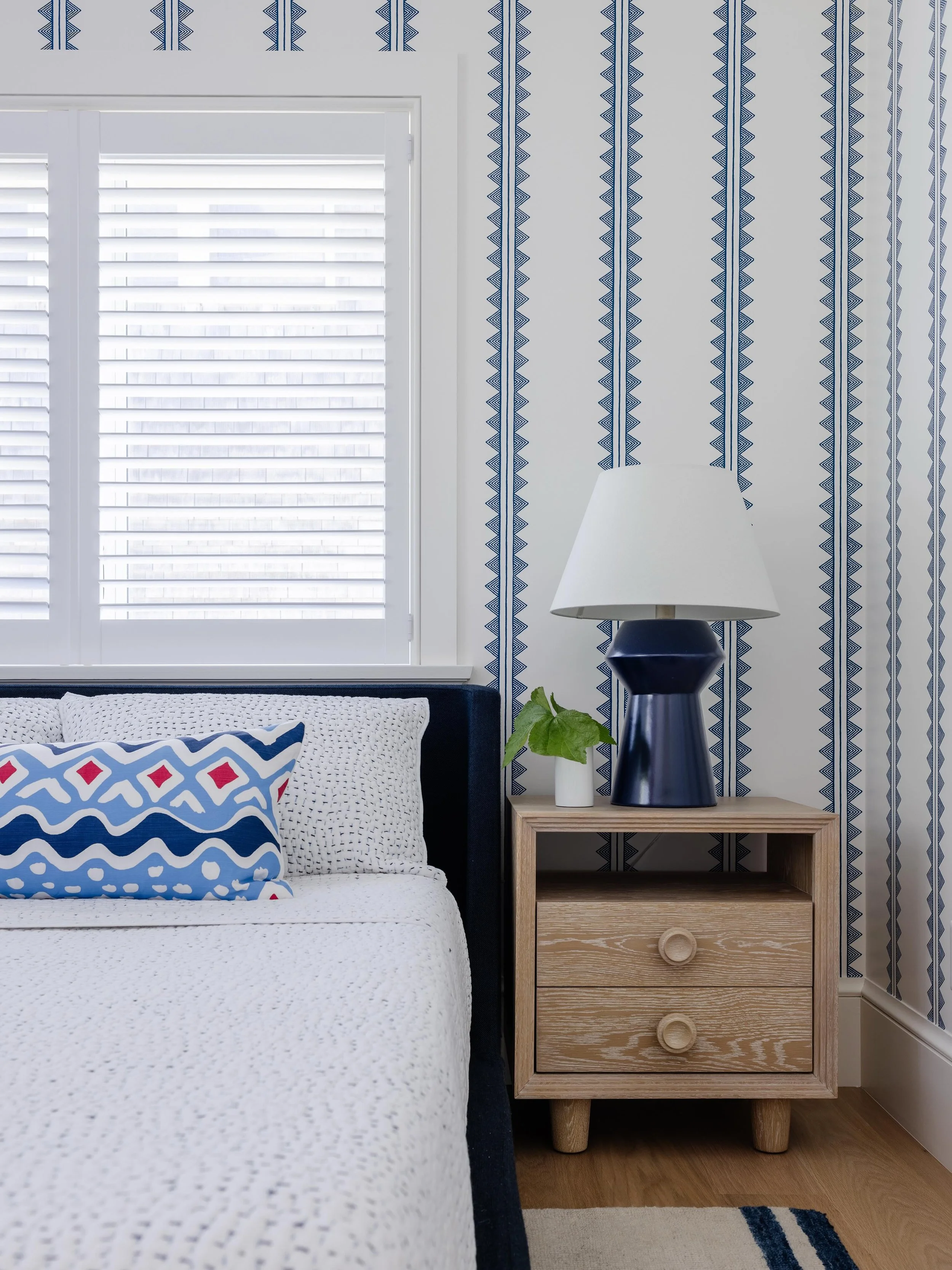 Pattern play done right. 💙 Geometric wallpaper meets tailored lines for a bedroom that feels fresh, crisp, and perfectly balanced. Instead of traditional beach motifs, this space achieves a sophisticated seaside aesthetic through a thoughtful mix of