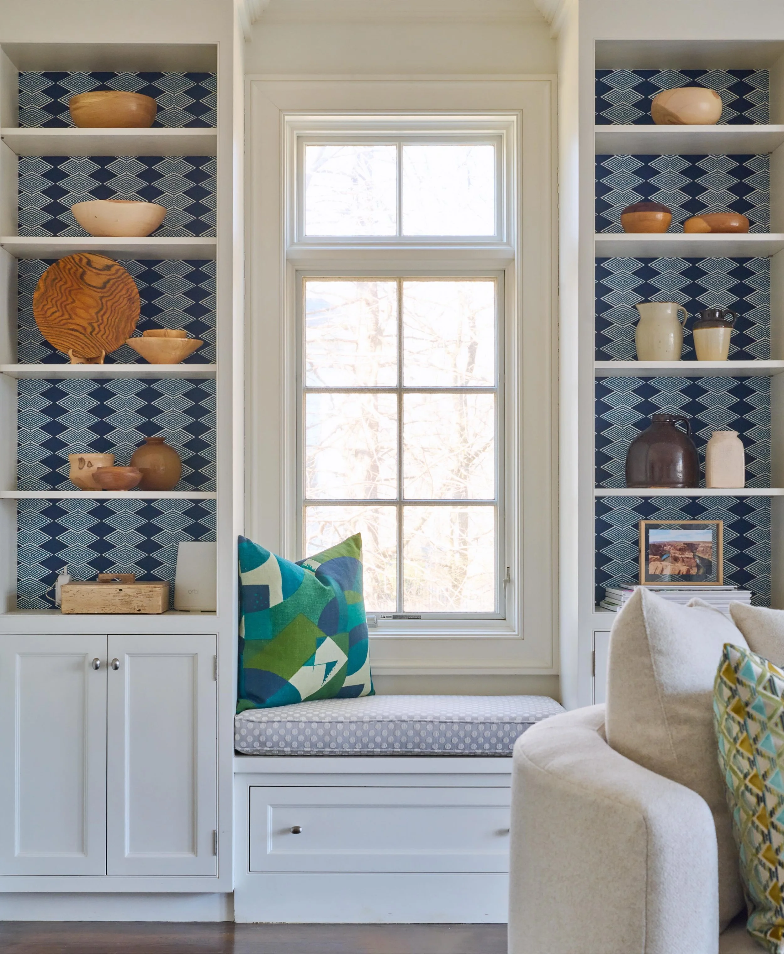 The secret to a memorable room is all in the layers. ✨ We paired crisp, classic white millwork with a bold geometric pattern to give the built-in shelving unexpected depth. Styled with a collection of wooden bowls handmade by the clients father- we l