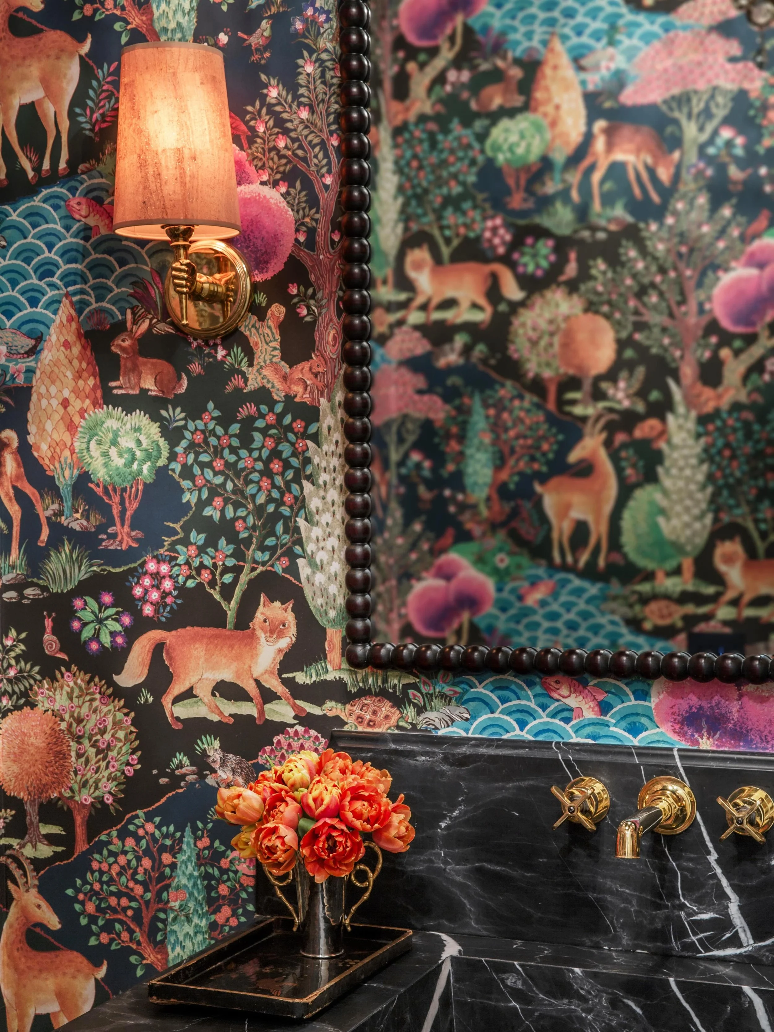 Small space, major impact. This powder room features a lush, enchanted forest wallpaper, a vintage vanity with custom dark marble top, and a custom bobbin mirror for the perfect dose of moody maximalism. 

@artwilliecole @lamaisonpierrefrey @urbanele