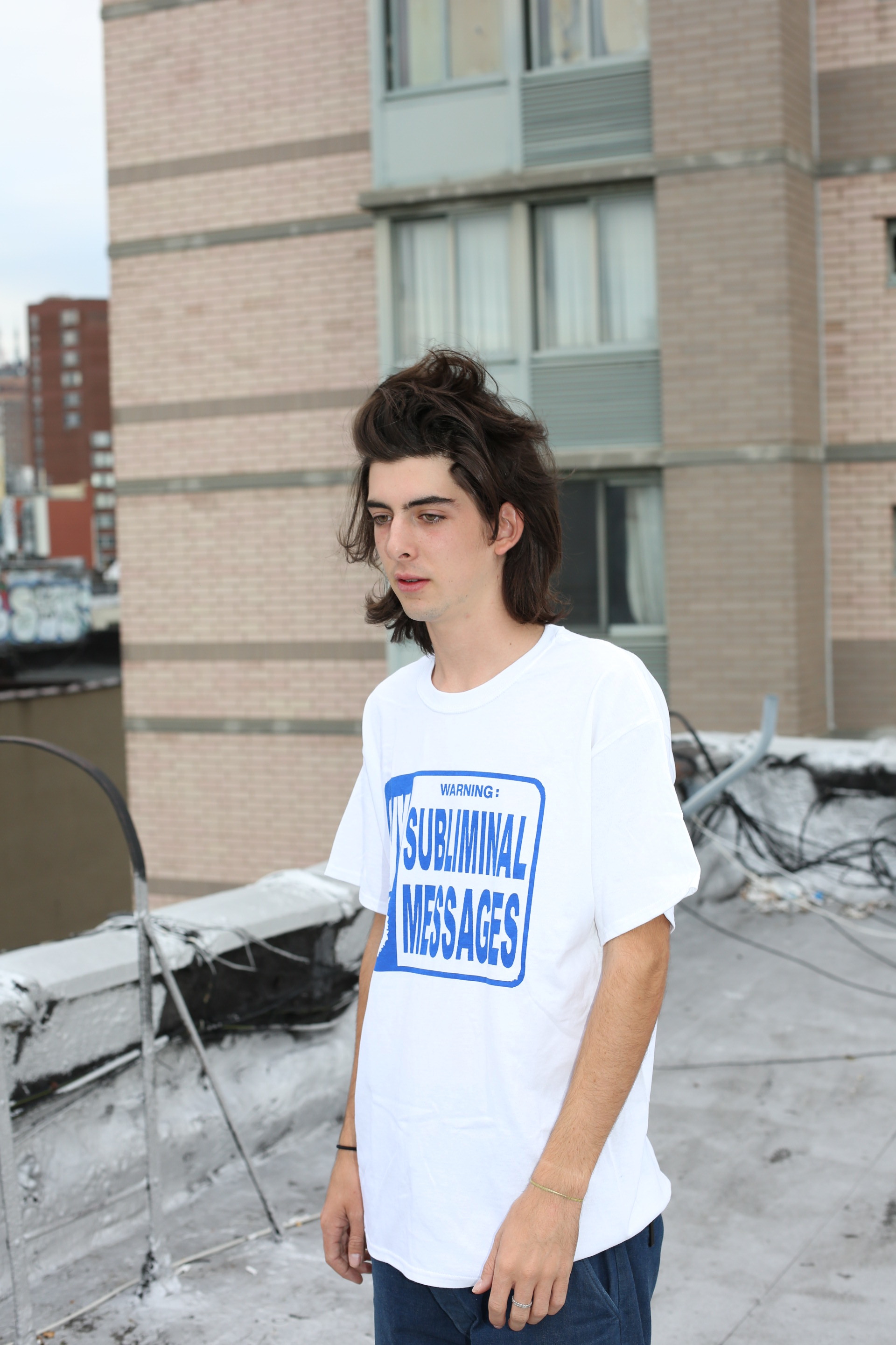 tucker wearing blue subliminal t in large