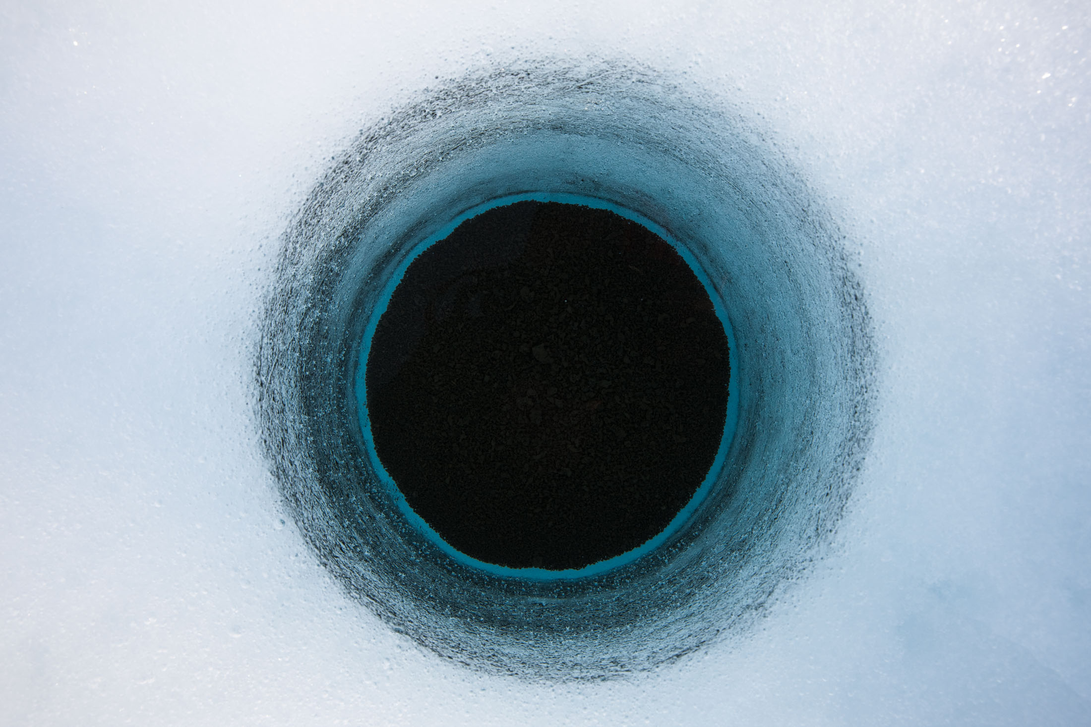 A hole made of cryoconite on the surface of the Greenland ice sheet