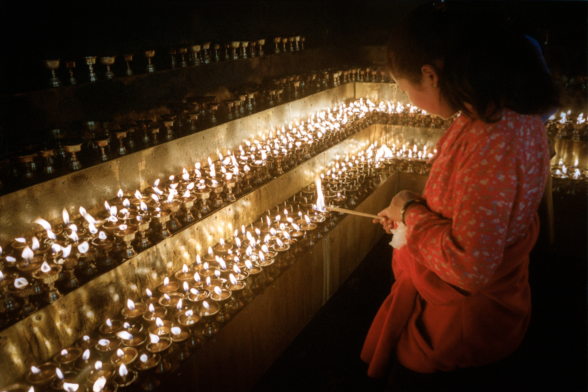 Lighting butter lamps outside the Jokhang Temple