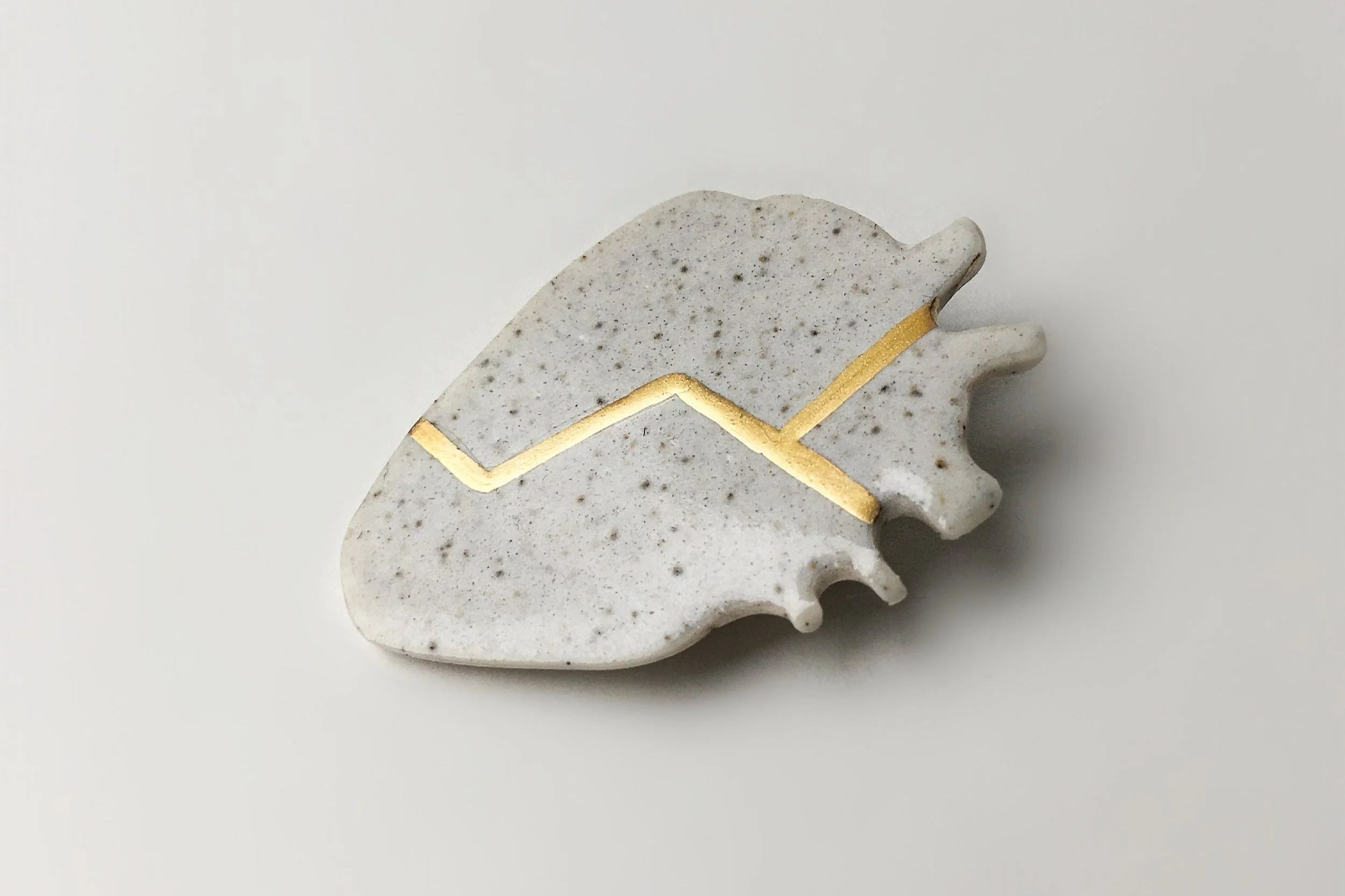 porcelain heart with gold tone lacquer - lacquered - unbroken heart pin - kintsugi - handmade ceramics - Studio Janneke - London United Kingdom