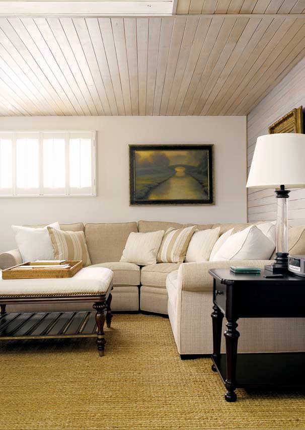 ALTIG COMMISSIONED RUGS FROM ASPEN CARPET DESIGNS “THEY DID THE RUGS FOR THE HOME IN THE MOVIE SOMETHING’S GOTTA GIVE WITH JACK NICHOLSON AND DIANE KEATON,” HE SAYS FOR UNDER THE DINING TABLE IN THE OPEN GREAT ROOM; THE COZY LIVING AREA FEATURES A COMFORTABLE SOFA, CHAIR AND OTTOMAN, BUT NO TELEVISION; ALTIG USED A MIX OF COLORED STONES FOR THE WALL BEHIND THE WOODSTOVE THAT IS ORIGINAL TO THE HOUSE.