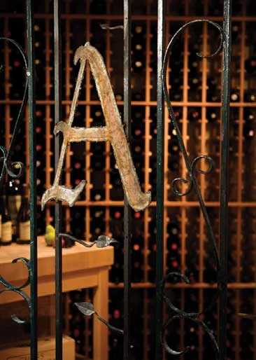Personalize your wine cellar with items that are meaningful to you and your family. For this Kirkland cellar, Randy Altig installed a salvaged iron gate and fitted it with a custom monogram. He chose mahogany wine racks from Wine Enthusiast (wine enthusiast.com) and a Boos butcher-block table from the Butcher Block Company (butcherblockco.com).
