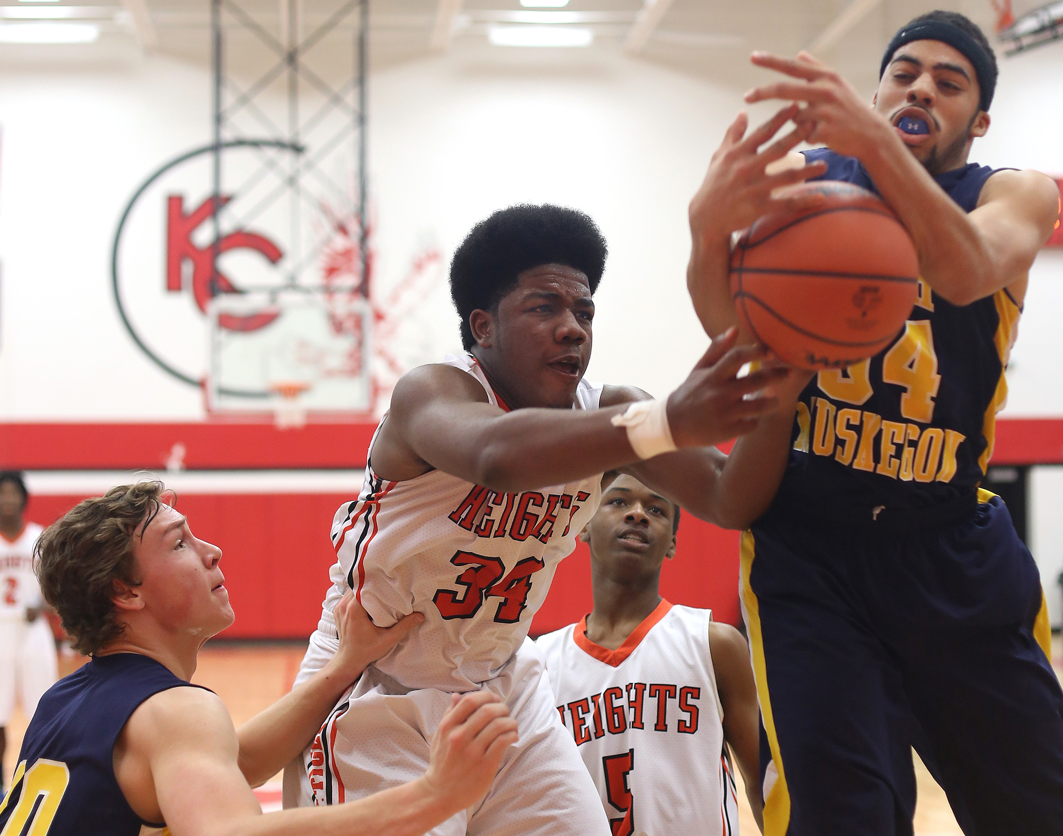 Keishon Watson (34) of Muskegon Heights Academy and Vernonell Smith of North Muskegon, right, fight for the rebound in the second quarter of their game at Kent City High School Friday, March 13, 2015. North Muskegon outscored the Tigers in a back-and-forth game to pull out the win and break the 12-year district drought.