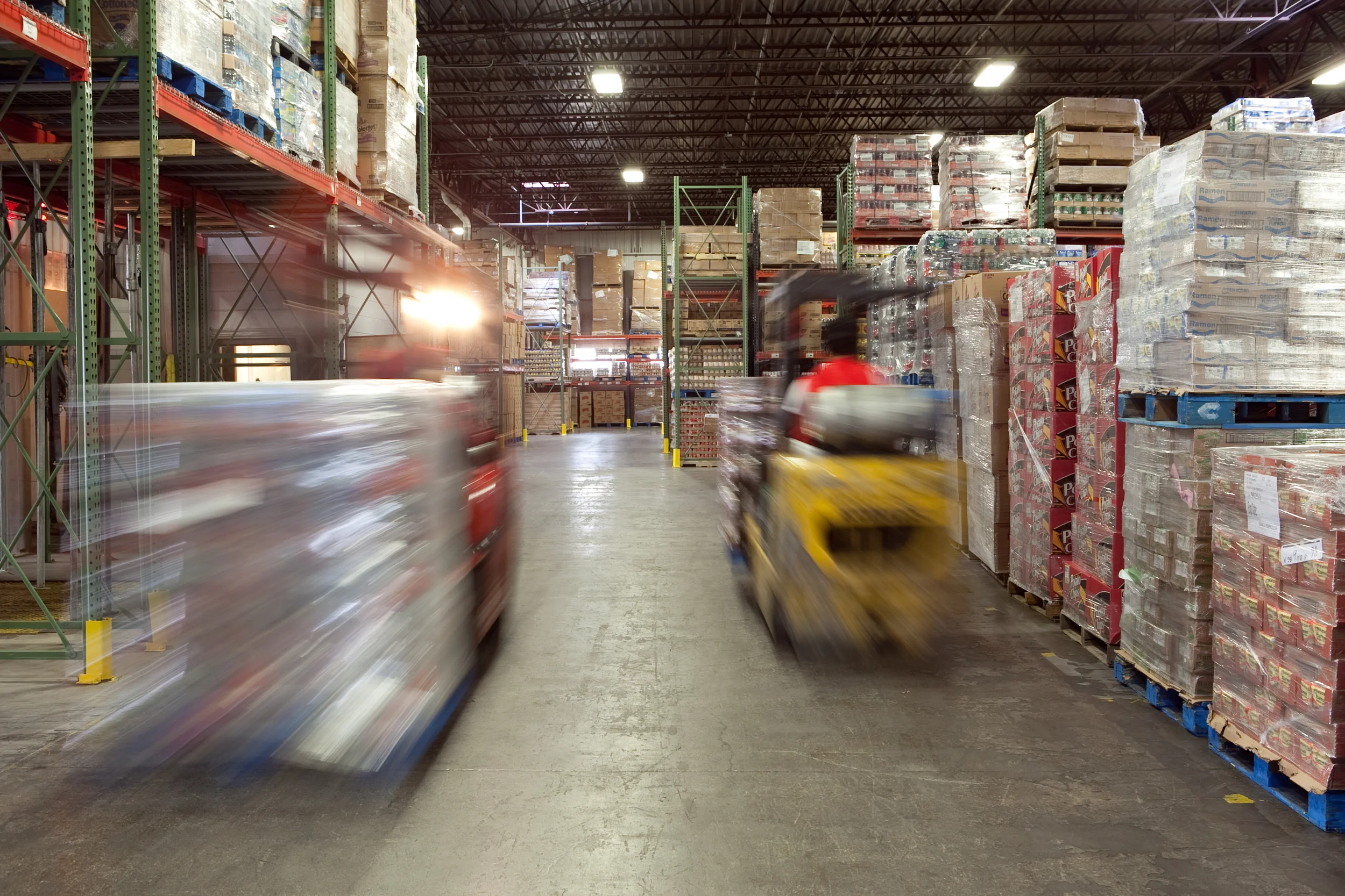Two Forklifts moving merchandise in the warehouse at D&B Grocers 