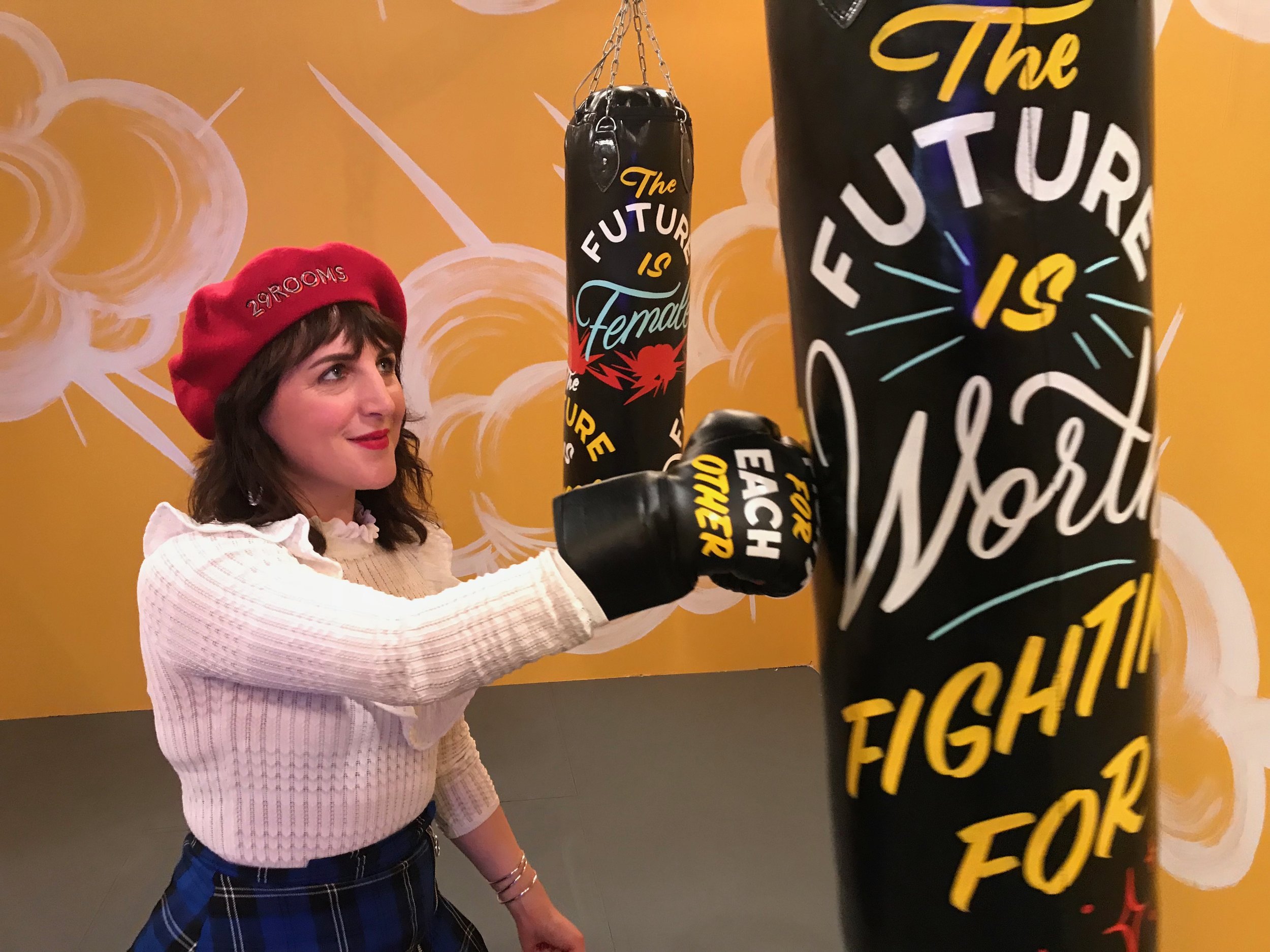 Piera Gelardi, executive creative director and co-founder of Refinery29, takes aim at a musical punching bag in the Future is Female room. Created in collaboration with musician Madame Gandhi and Jen Mussari, the punching bags are covered in lyrics from Gandhi's songs. When visitors punch them, it triggers different sounds. Photo credit: Adriana Cargill