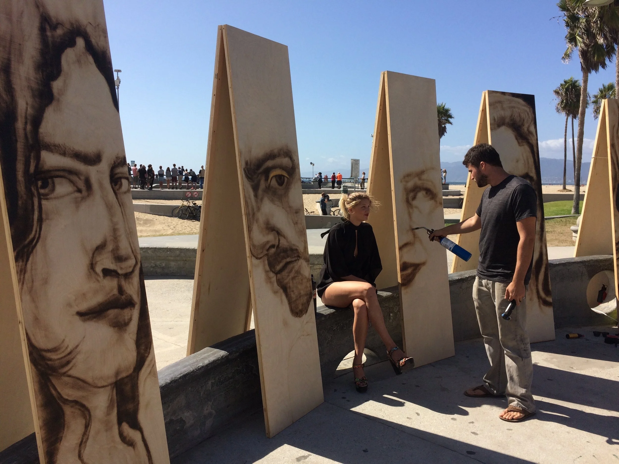 Zachary Aronson works on a portrait of Tazi Apple on the Venice Boardwalk. Photo credit: Adriana Cargill
