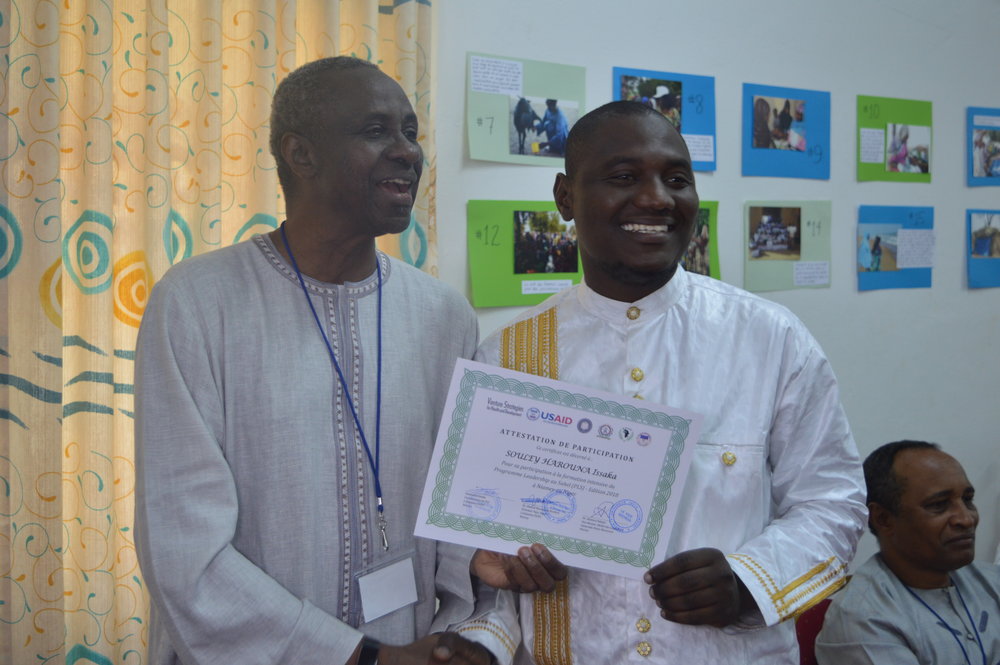 Cheikh Mbacke, expert démographe, remet une attestation de participation à la formation intensive au lauréat du PLS Souley Population expert Cheikh Mbacke delivers SLP Fellow Souley’s intensive training certificate