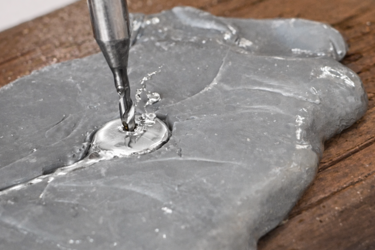 Molten silver and drill bit in focus.png