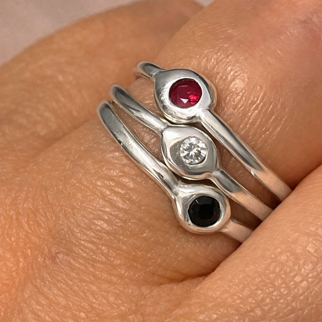 Stacked sterling silver rings with gemstones.png