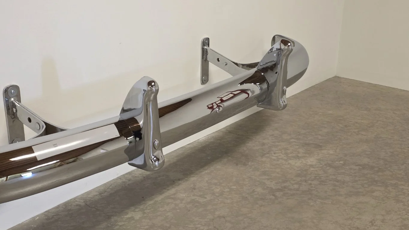 Allan Graham \ Toadhouse Bent light bent back 1990 10 ½ x 69 ⅝ x 18 ⅞ inches Chrome auto bumper with vinyl bumper sticker