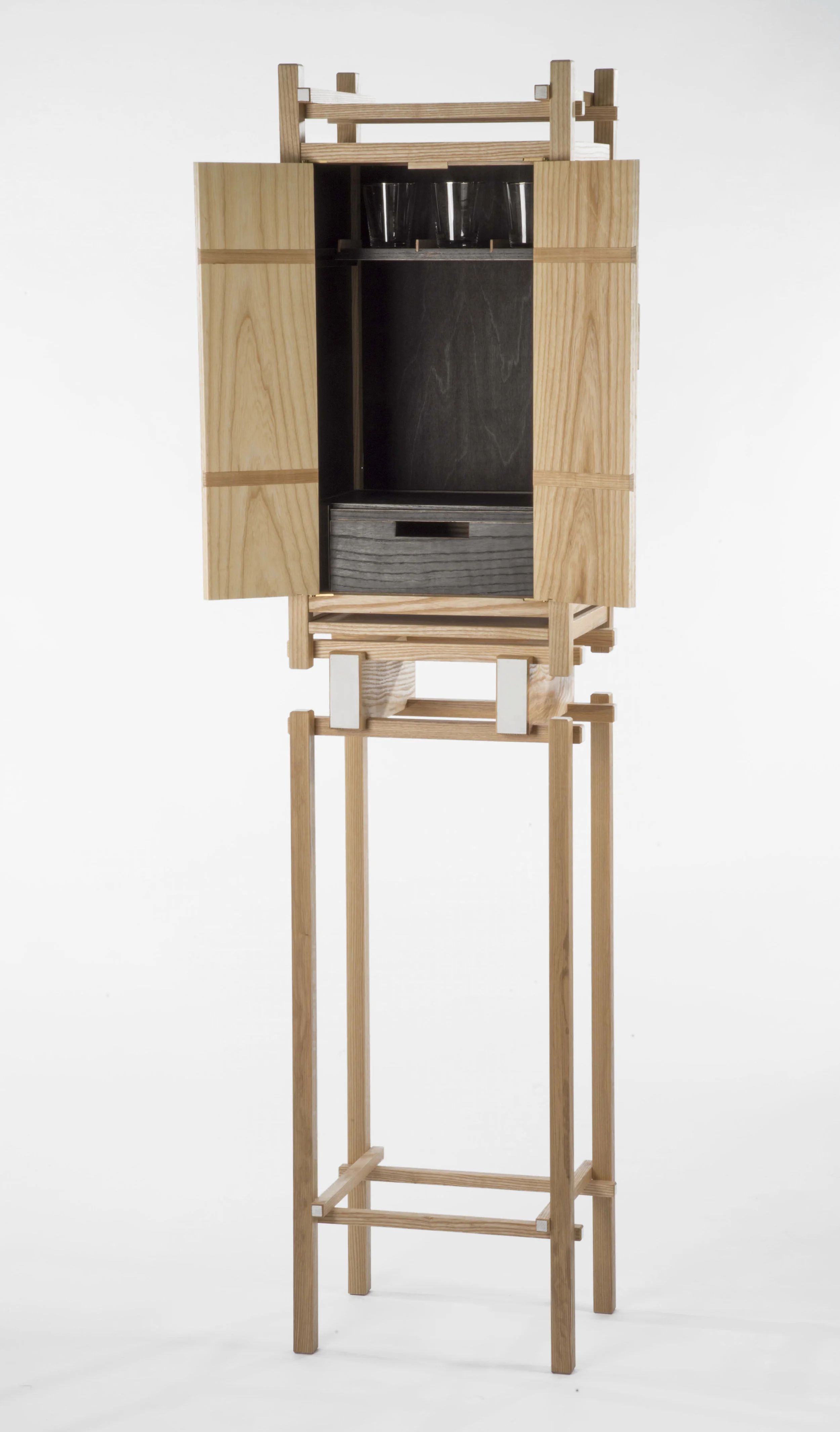 Liquor Cabinet is designed within the constraints of a three part construction system: two sizes of square stock, floating panels, and pinned butt joints. The use of square stock and panels allow for attention to be placed on the intersecting horizontal and vertical lines. Materials: Ash wood H 72” x L 17” x W 13”