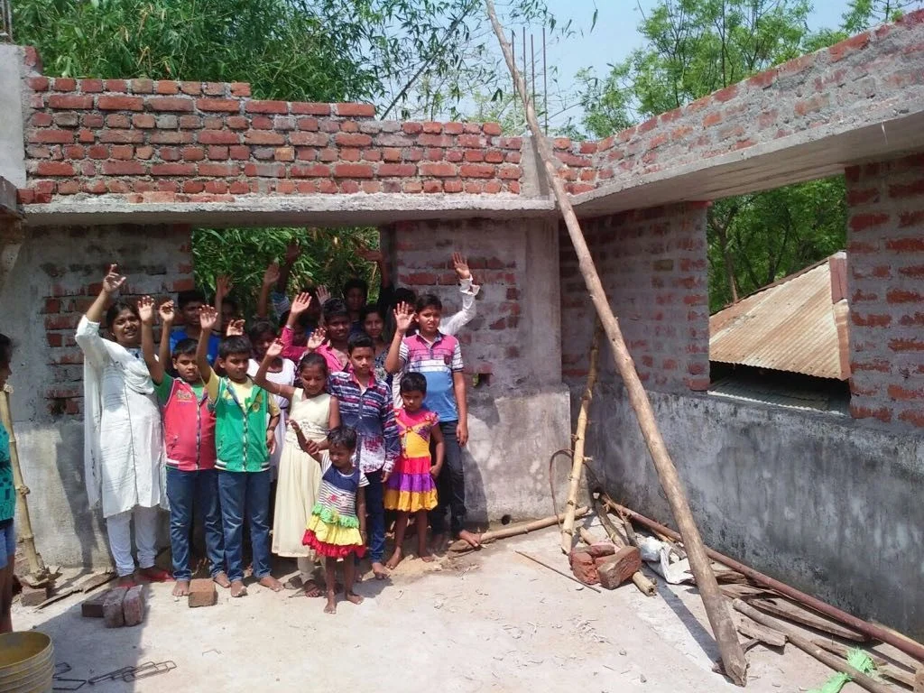 Asha Griha Kids Waving On Roof.jpg