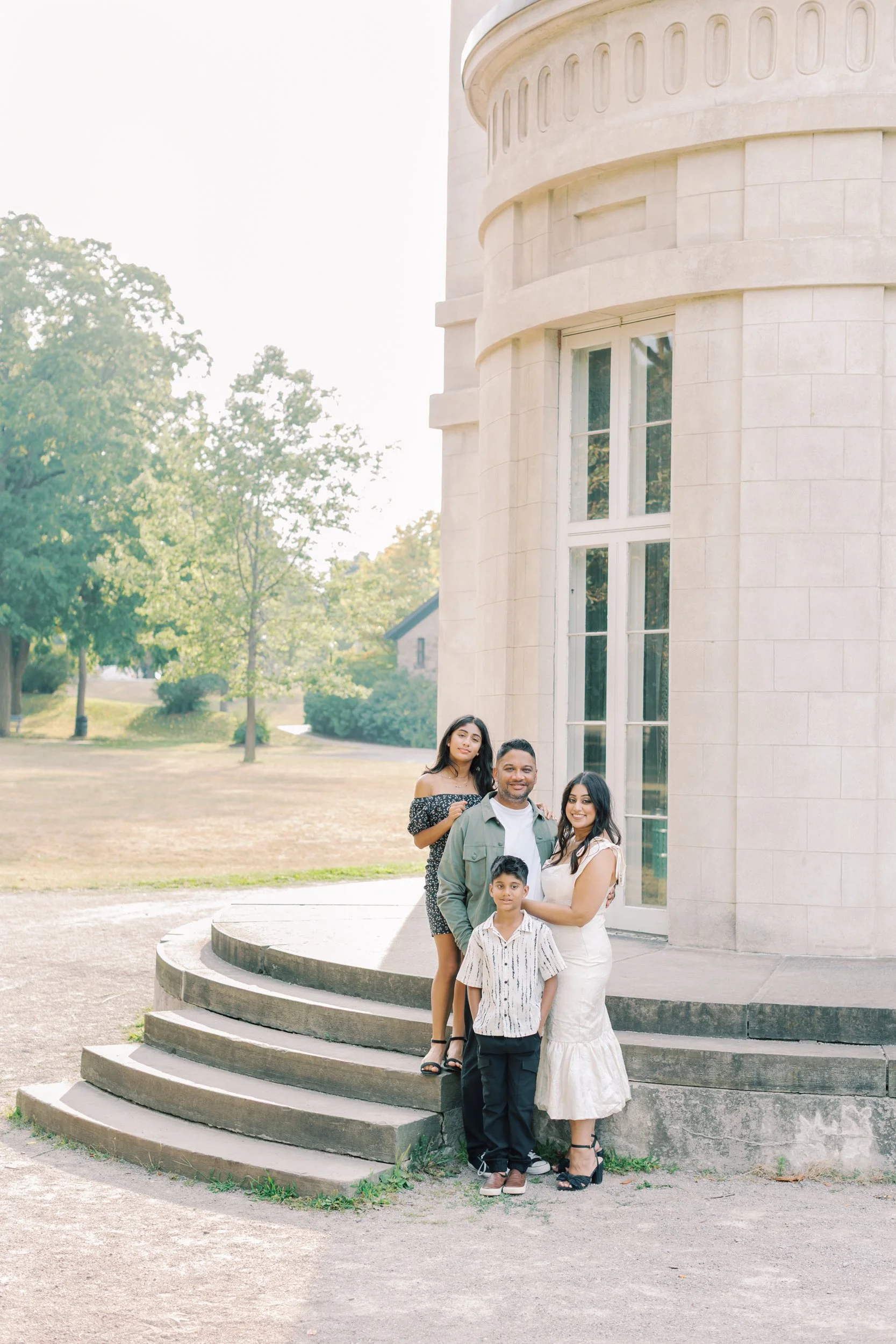 A family wearing coordinated neutral outfits including linen and knits during a sunset session in Burlington.