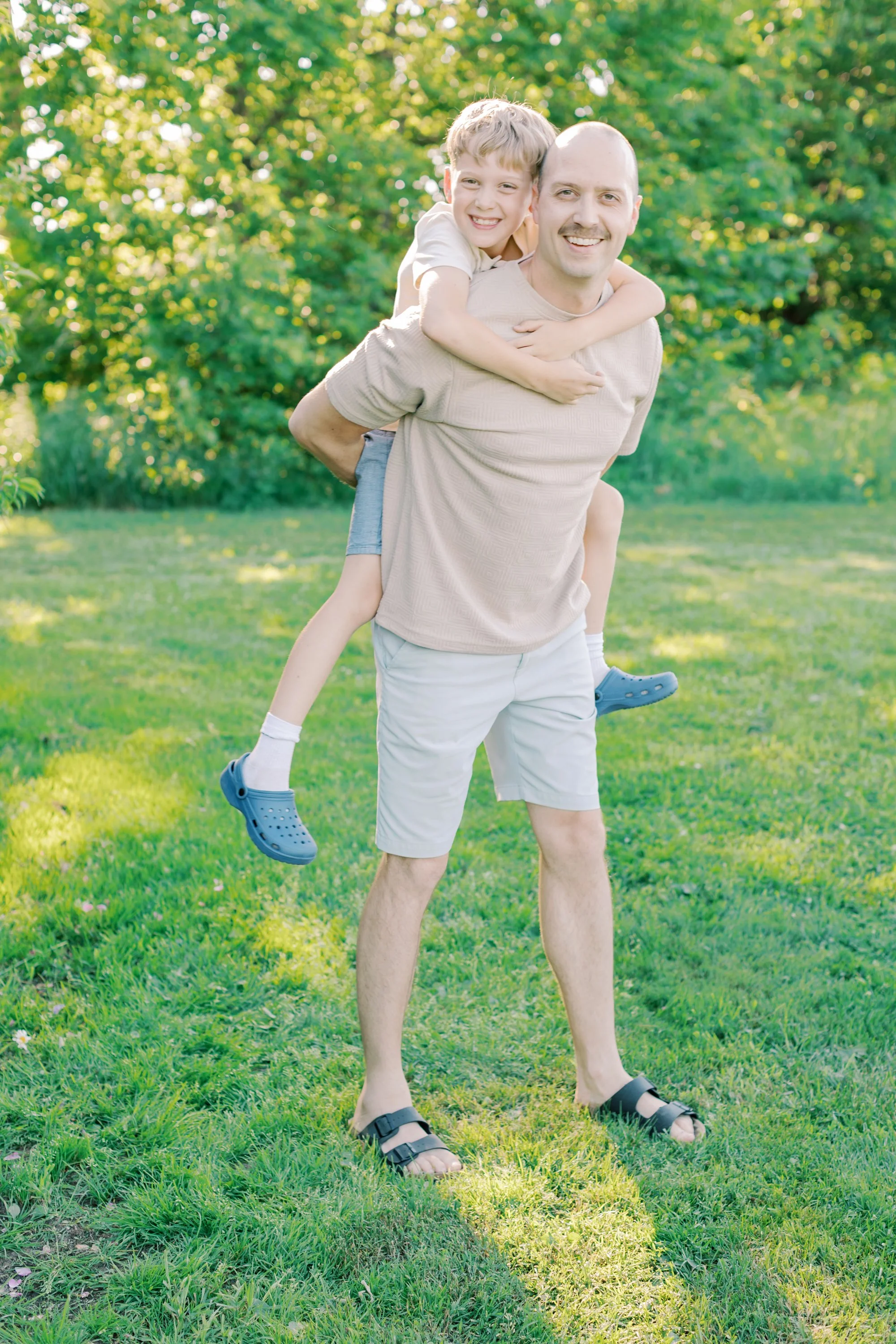 A candid and emotional family portrait captured by a Burlington family photographer in an open, natural field.