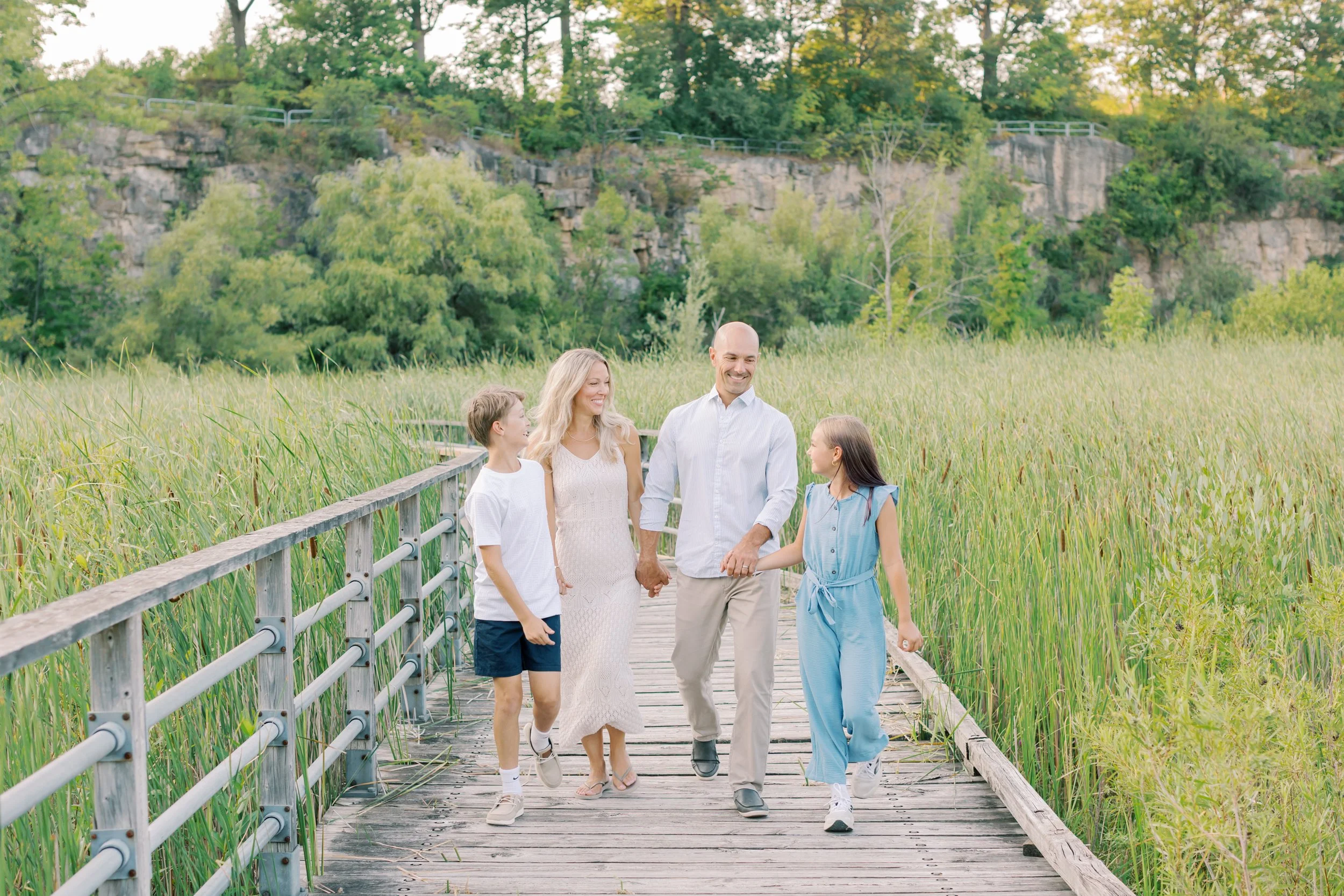 A family walking along the boardwalk during a lifestyle session at Kerncliff Park in Burlington, Ontario.