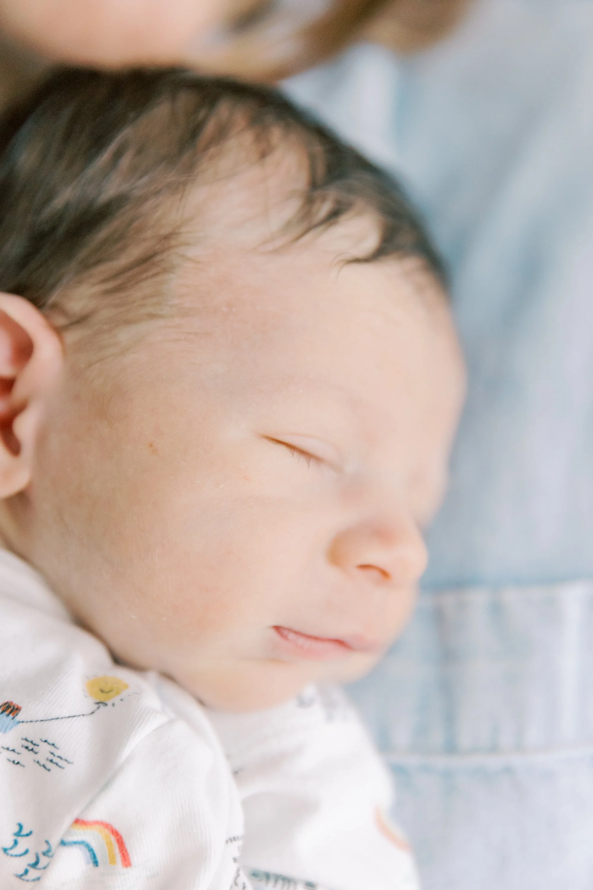 Mother cuddling newborn during a natural newborn photography session in an Oakville home.