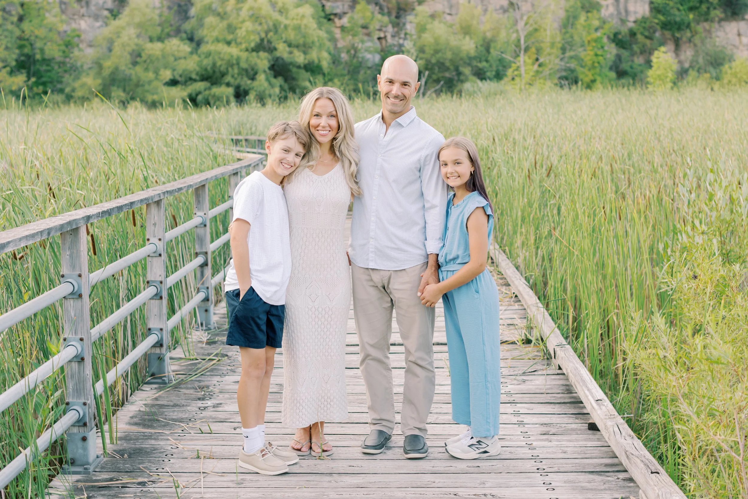 A family walking along the boardwalk during a lifestyle session at Kerncliff Park in Burlington, Ontario.