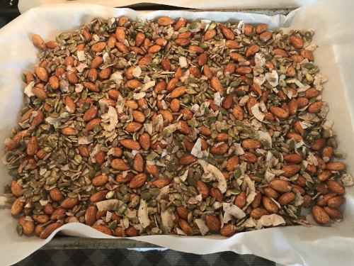 nuts and seeds on parchment paper lined baking sheet