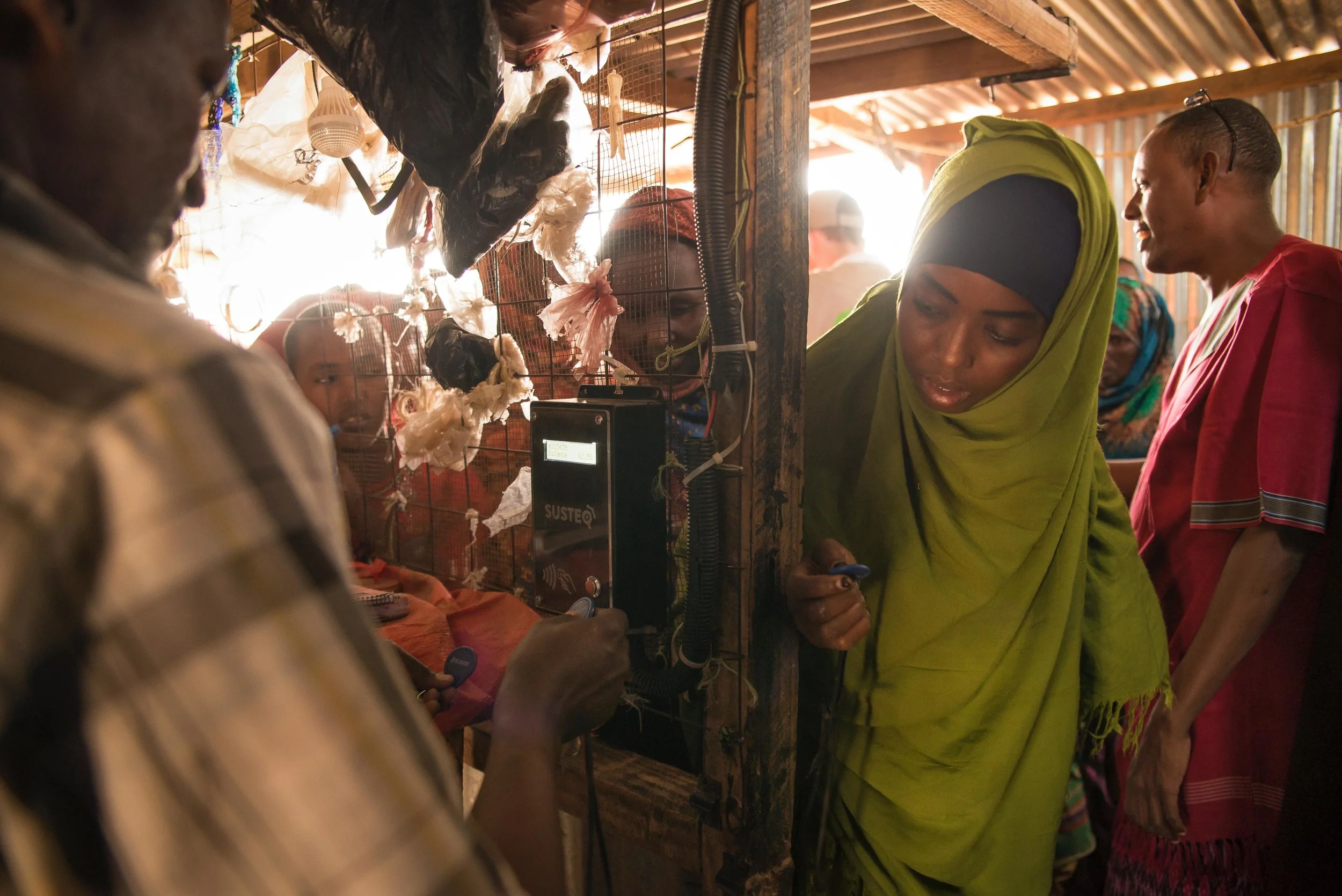 Zeinab Issa, 28, waits for the shop owner to top-up her Water ATM token in Hadado, Kenya.