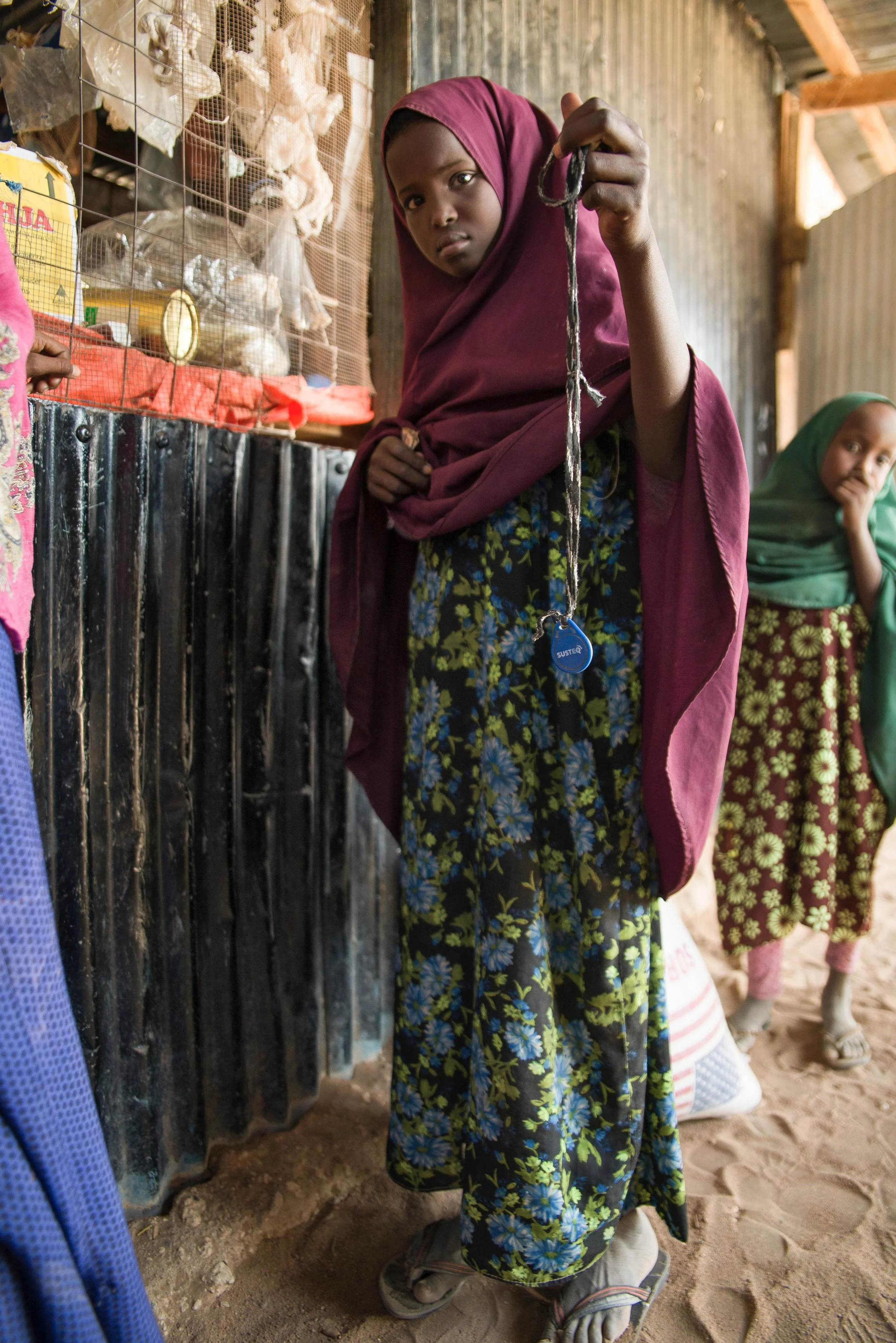 Sahara Ali Omar, 10, holds a water credit toiken outside a Water ATM top-up shop in Hadado town in Northern Kenya.