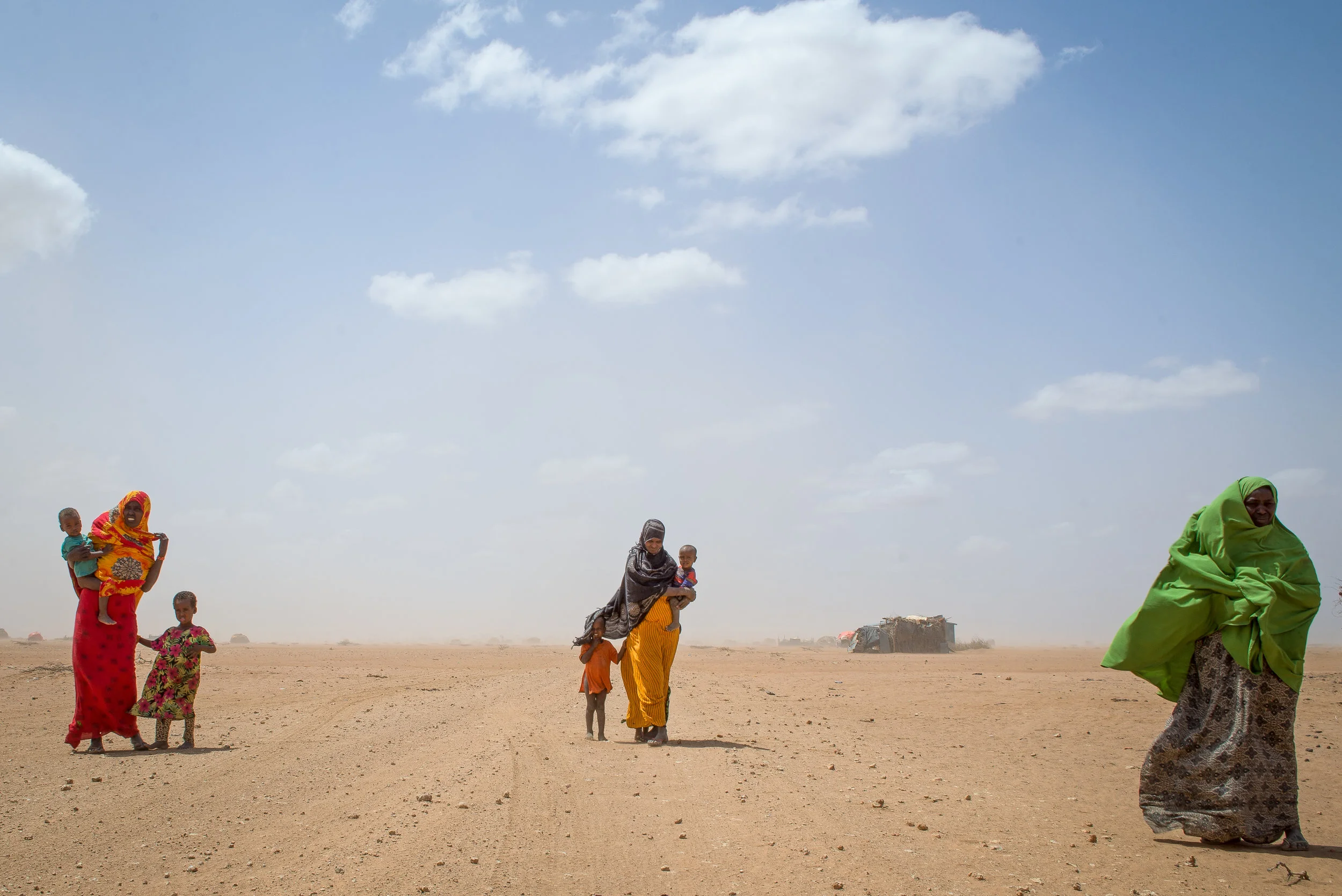 Women carry their children through a sandstorm in a remote village of Wajir County, Kenya. Photo: Katie G. Nelson, Oxfam