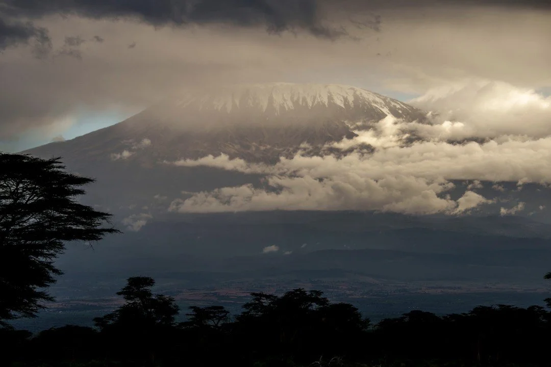 Shrouded in a cloak of cloud, the snow-capped peak of Africa&rsquo;s tallest mountain is barely visible, as dusk takes hold of this iconic landscape. Kilimanjaro, and the surrounding hills that make up the area, is more than a mountain. It&rsquo;s a 