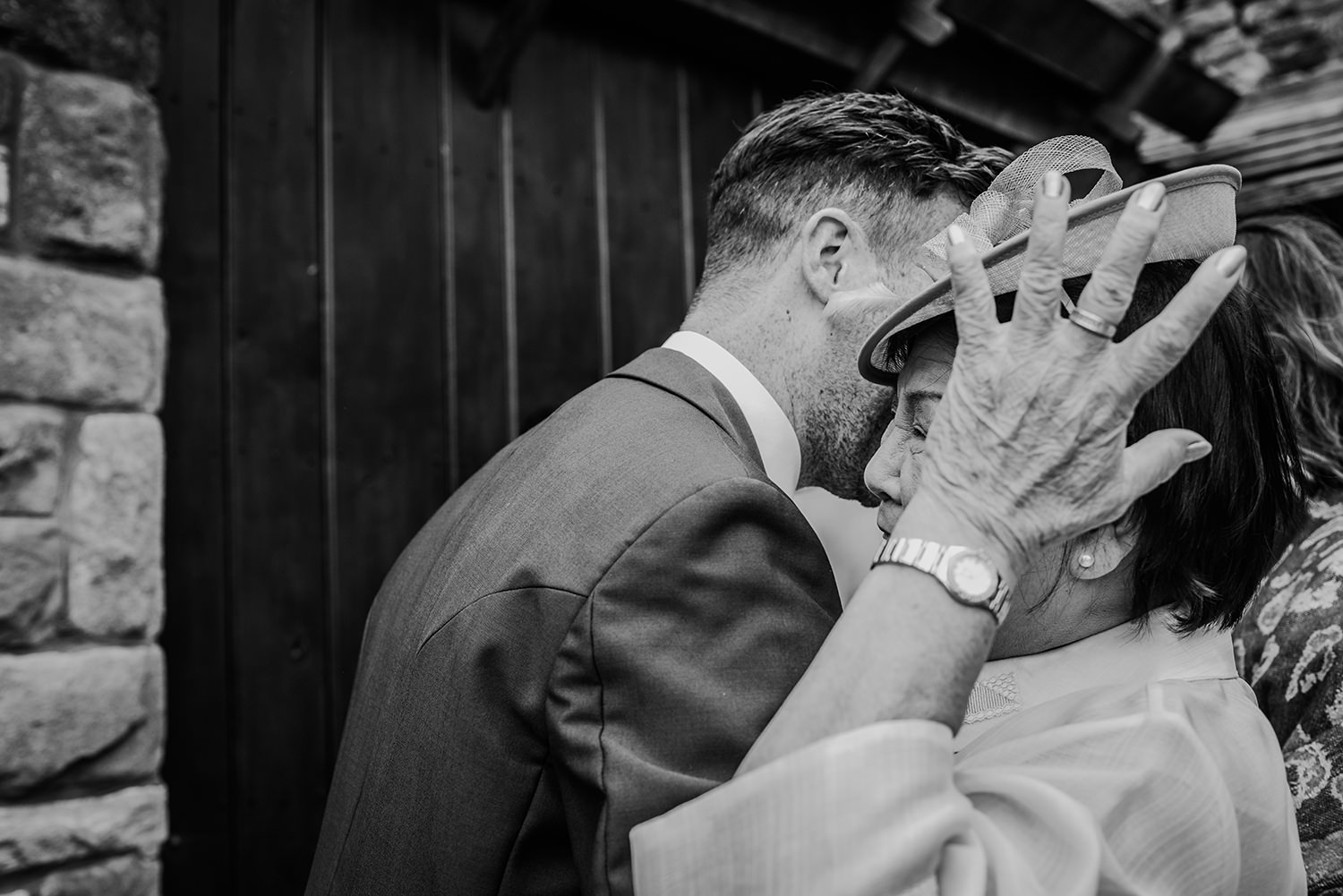  black and white photo groom hugging friend 