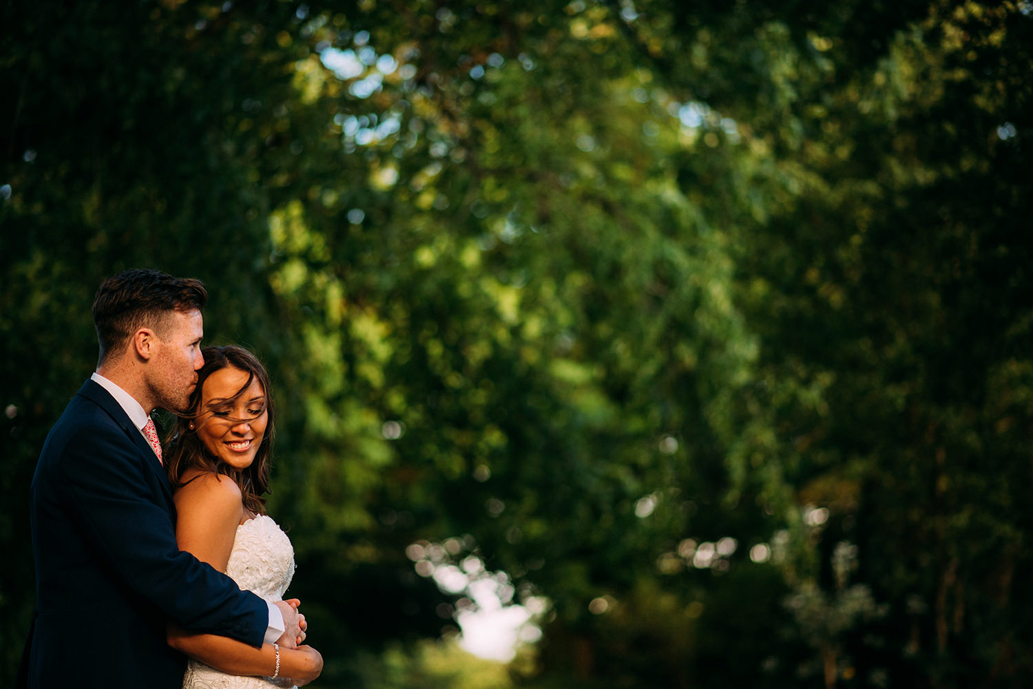  colour photo of bride and groom hugging 