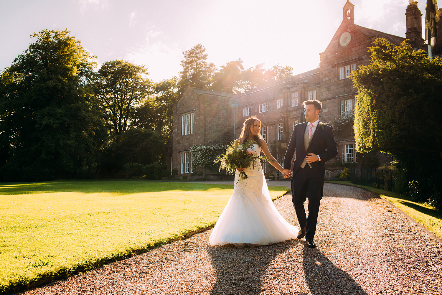  bride and groom walking past hall, in colour 