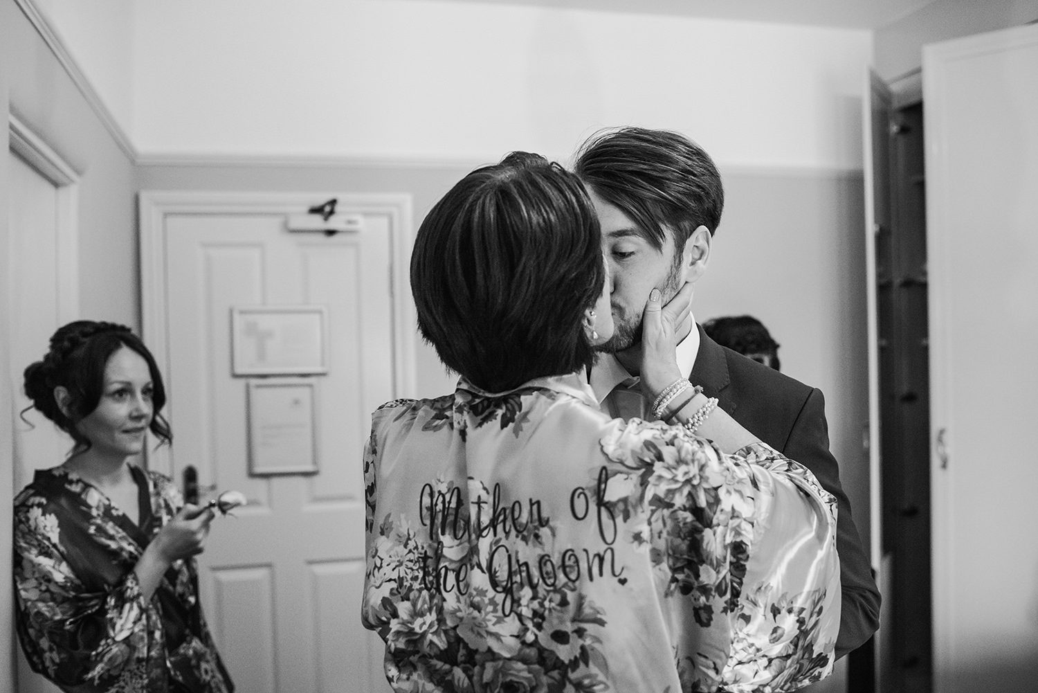 Grooms mother giving him a kiss