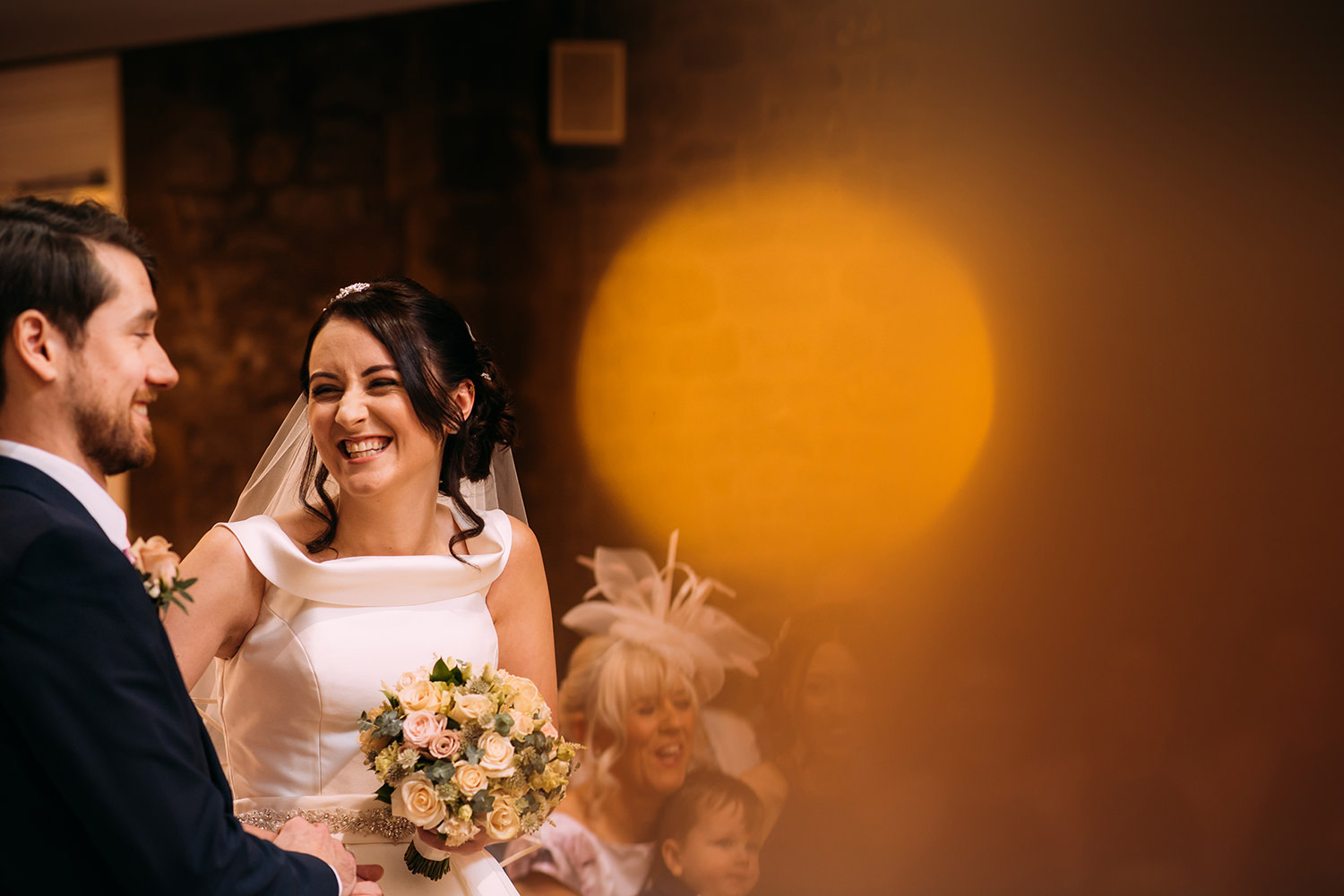 bride and groom in service, with orange bokeh 