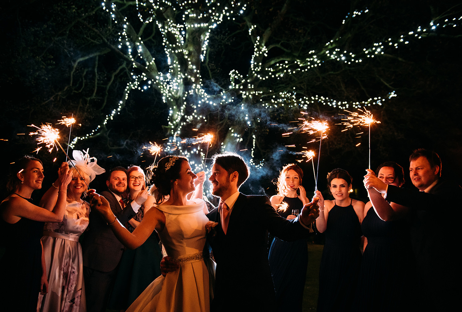  bride and groom with friends and sparklers 