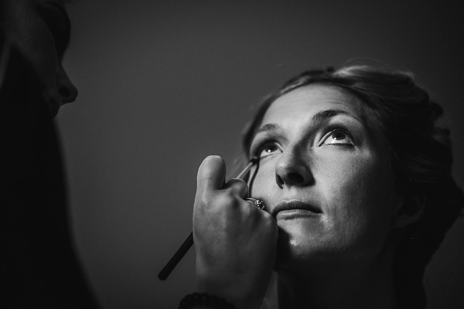  black and white image of bride having make up done 