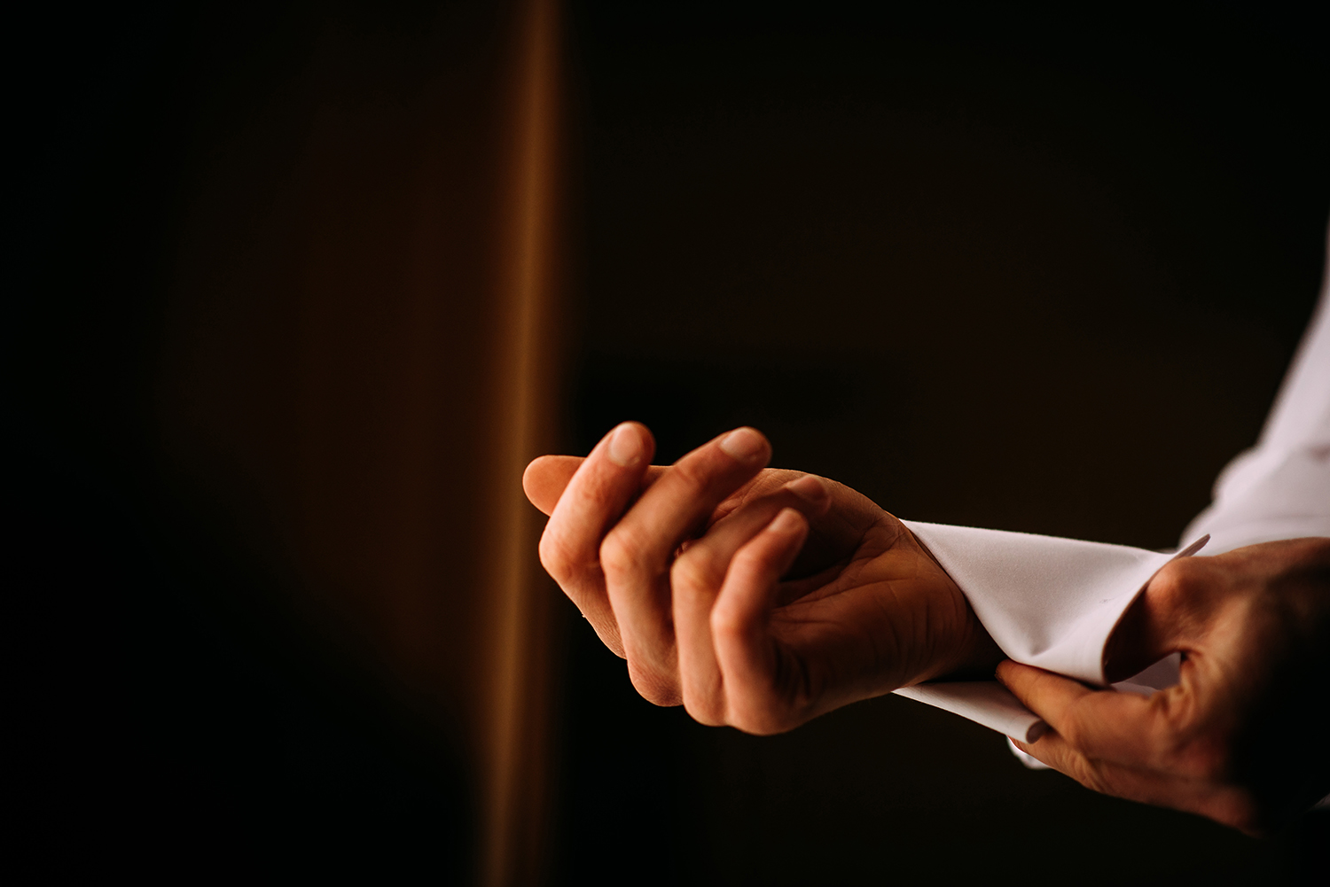  groom fastening cuff links on shirt 