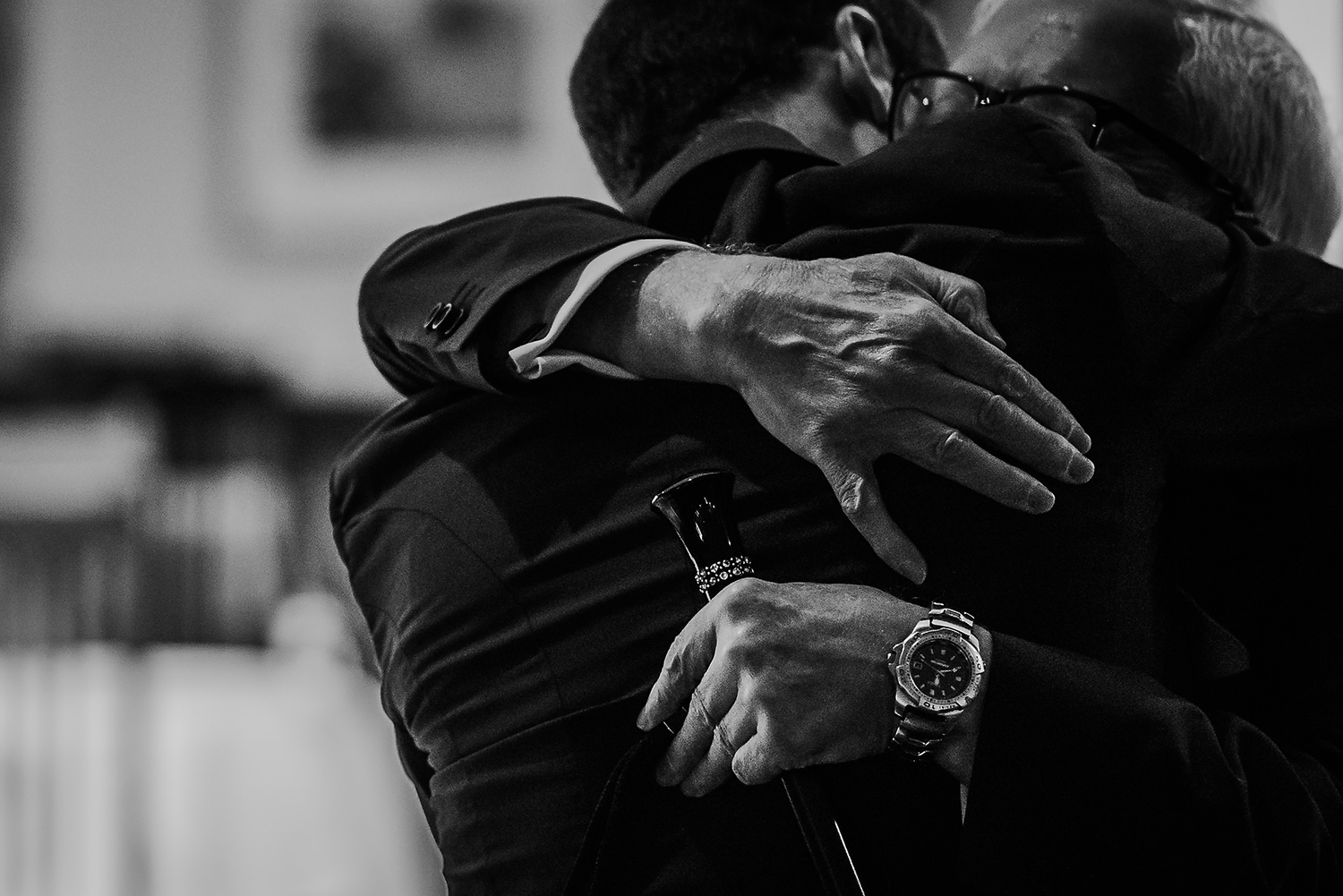  black and white image of groom hugging father of the bride 