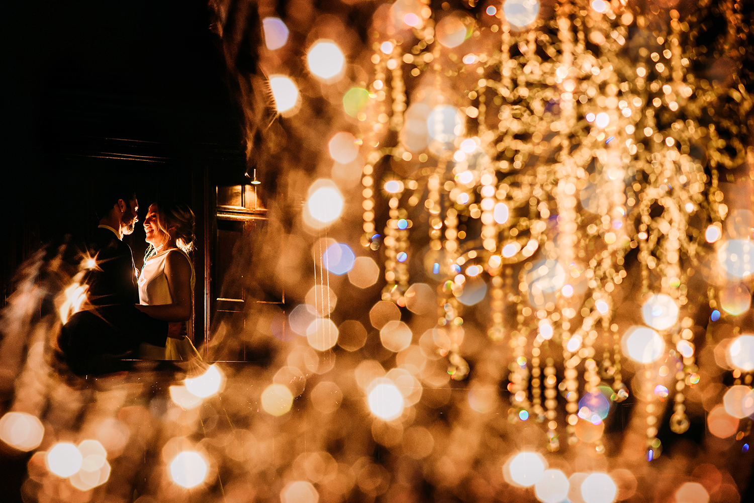  bride and groom flash photo shot through Mitton halls huge chandelier 