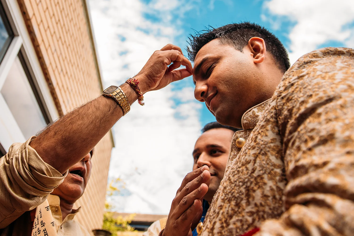Groom having rice put on his forehead during his entrance