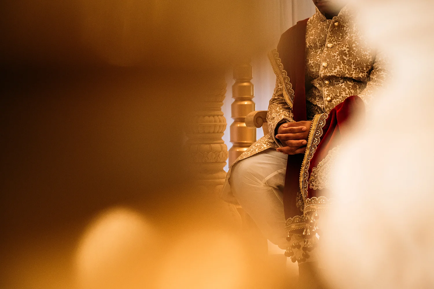 grooms hand shot through candle and ornaments