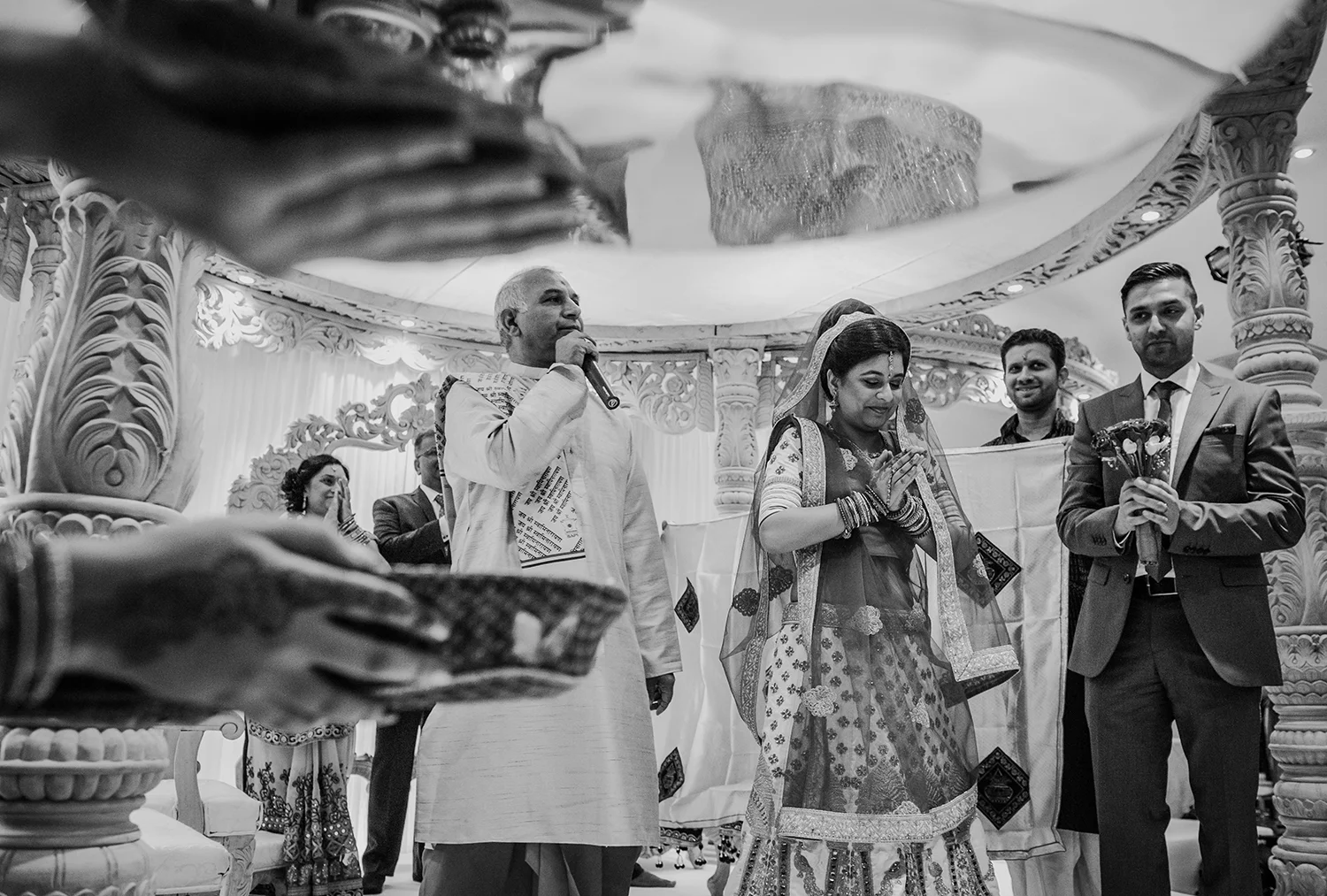 bw photo of bride praying while facing the guests