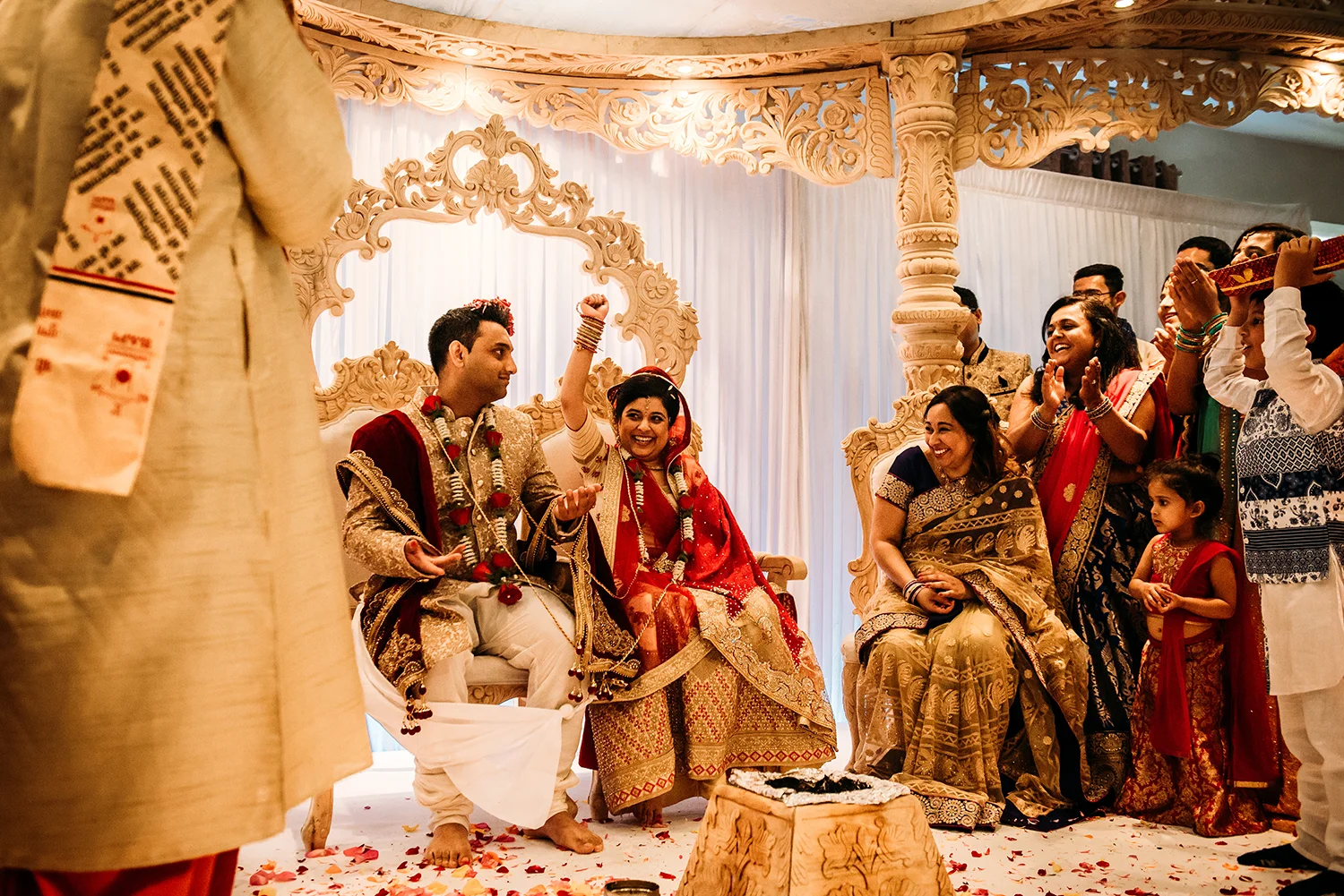 bride and groom laughing with family on the stage