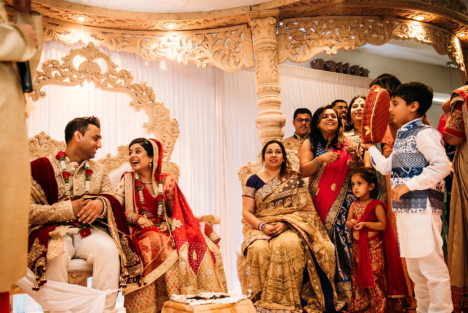 bride and groom laughing with family on the stage